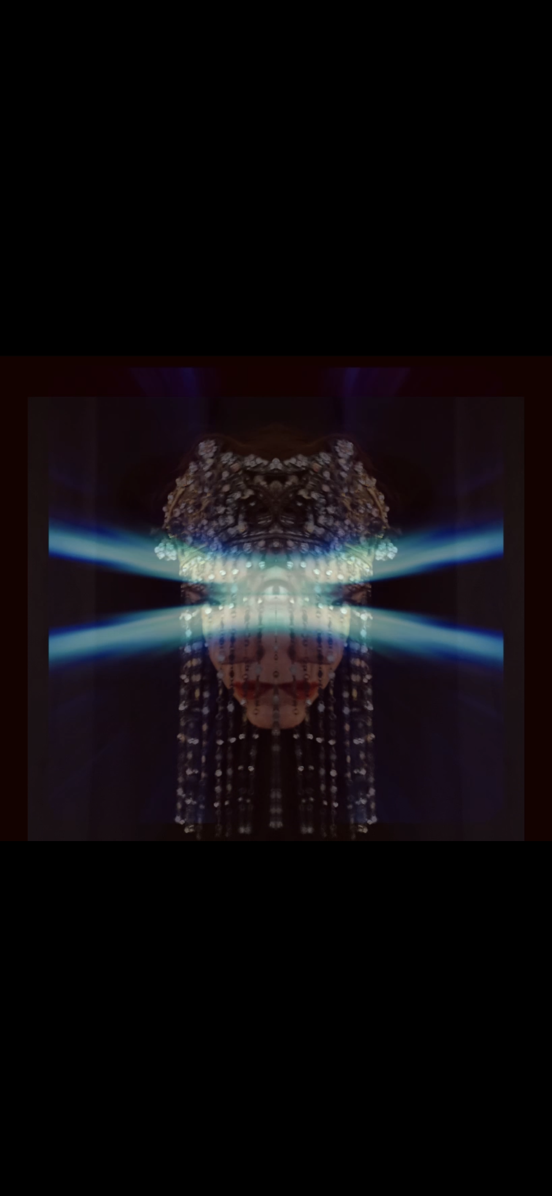 Abstract digital artwork featuring symmetrical patterns with bright blue and white light beams, resembling a futuristic face or mask.