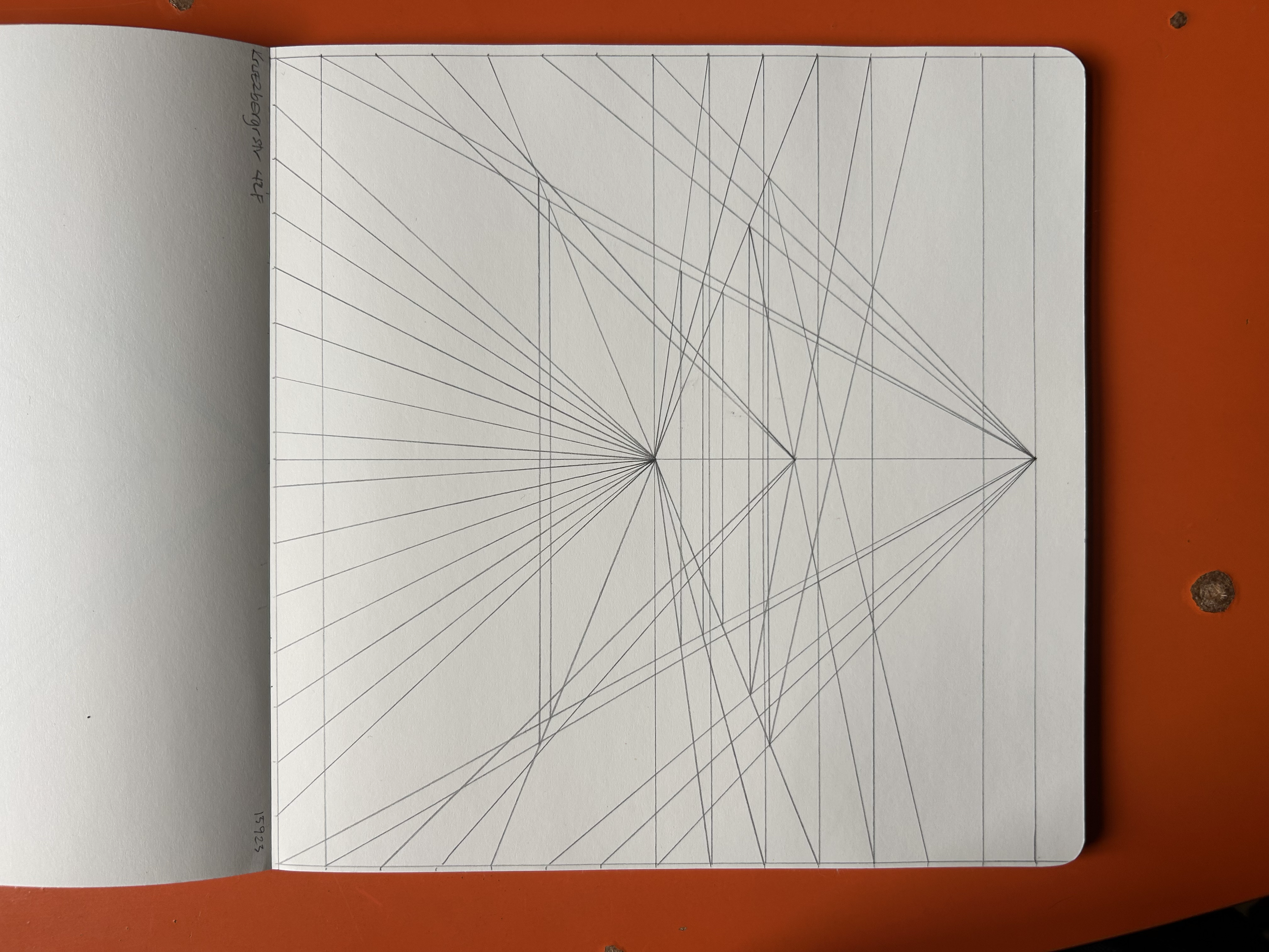 A notebook with multiple straight lines drawn with a pen, creating a geometric pattern.