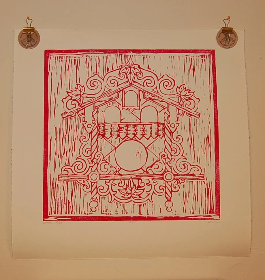 Red and white artwork of a birdhouse with decorative scrolls and leaves, framed in red.