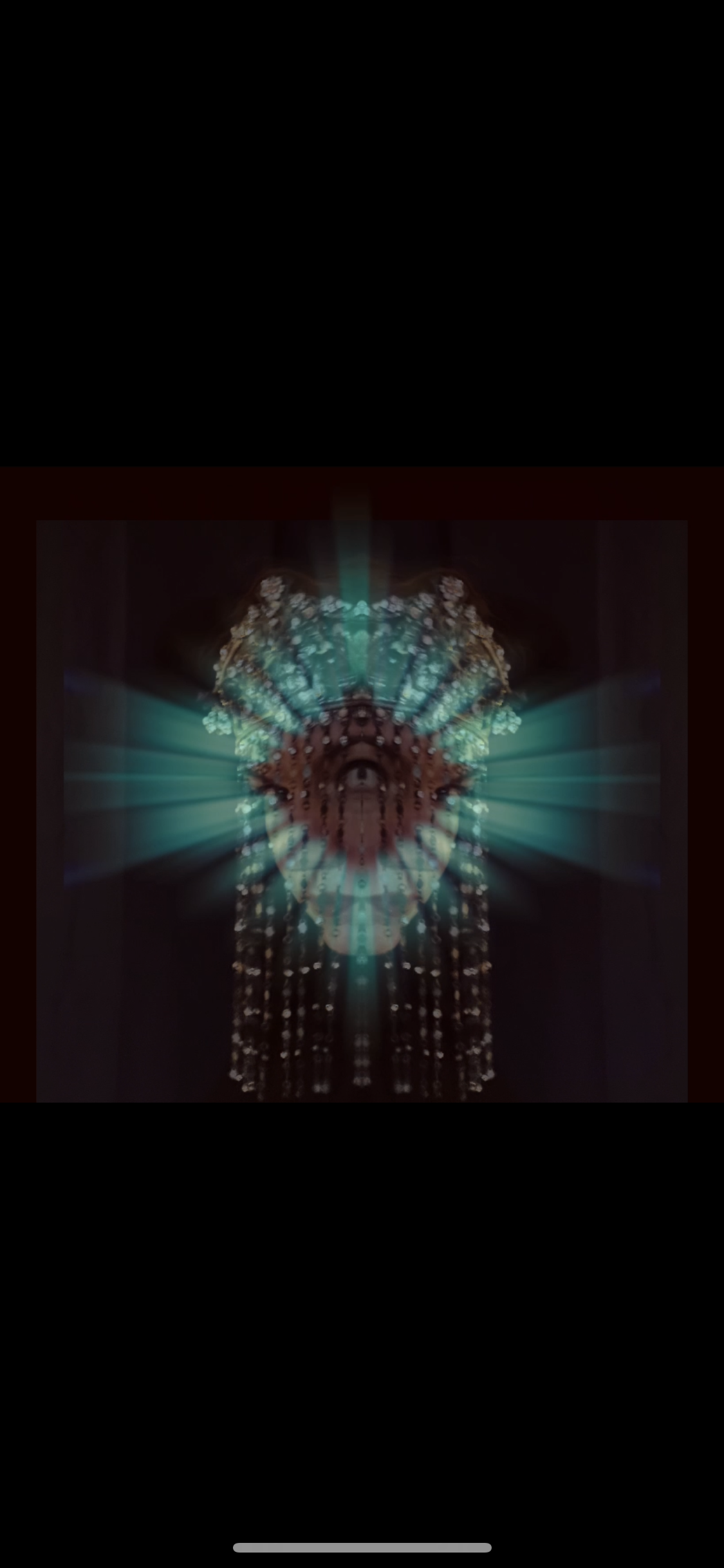A digitally manipulated image with a mirrored, ornate chandelier against a dark background, featuring glowing lights and symmetrical patterns.