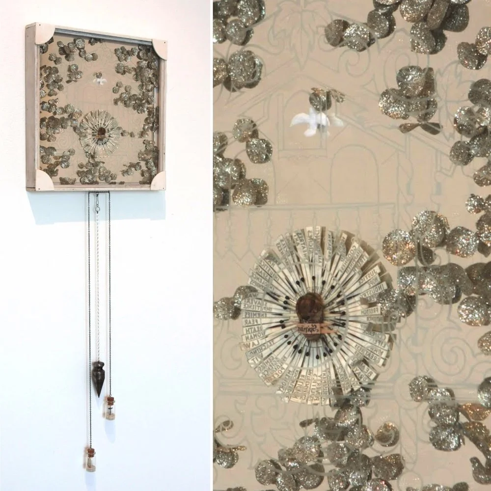 A wall clock with a square white frame and black chains hanging down, featuring a decorative face with artistic elements, surrounded by a scattering of silver glittery spheres or decorations.