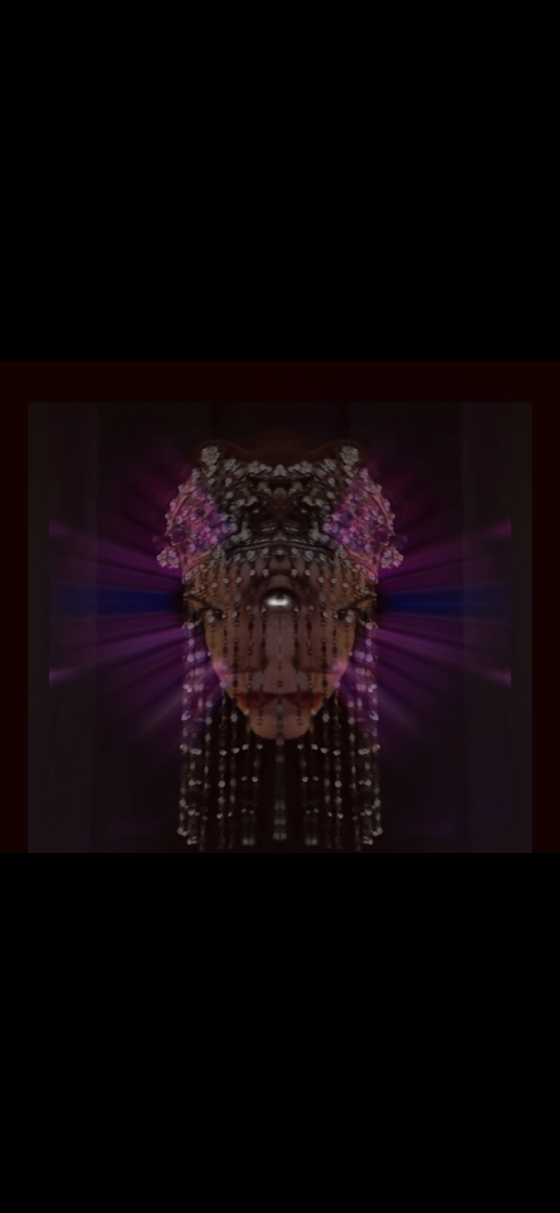 A digital artwork of a butterfly with a human face in the center, surrounded by colorful light rays and floral patterns.