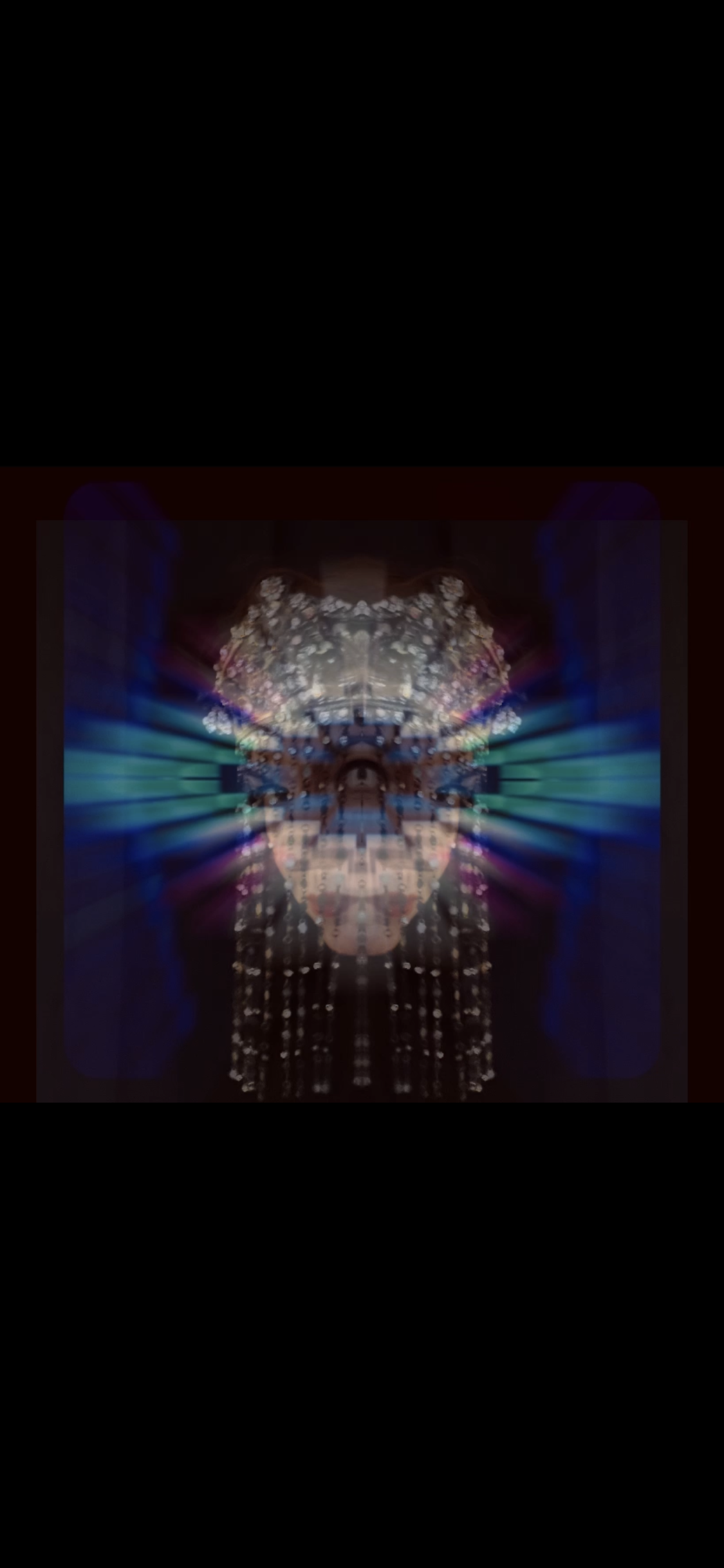 A digitally manipulated, symmetrical image featuring a person's face with mirror-like effects, colorful lights, and abstract patterns.