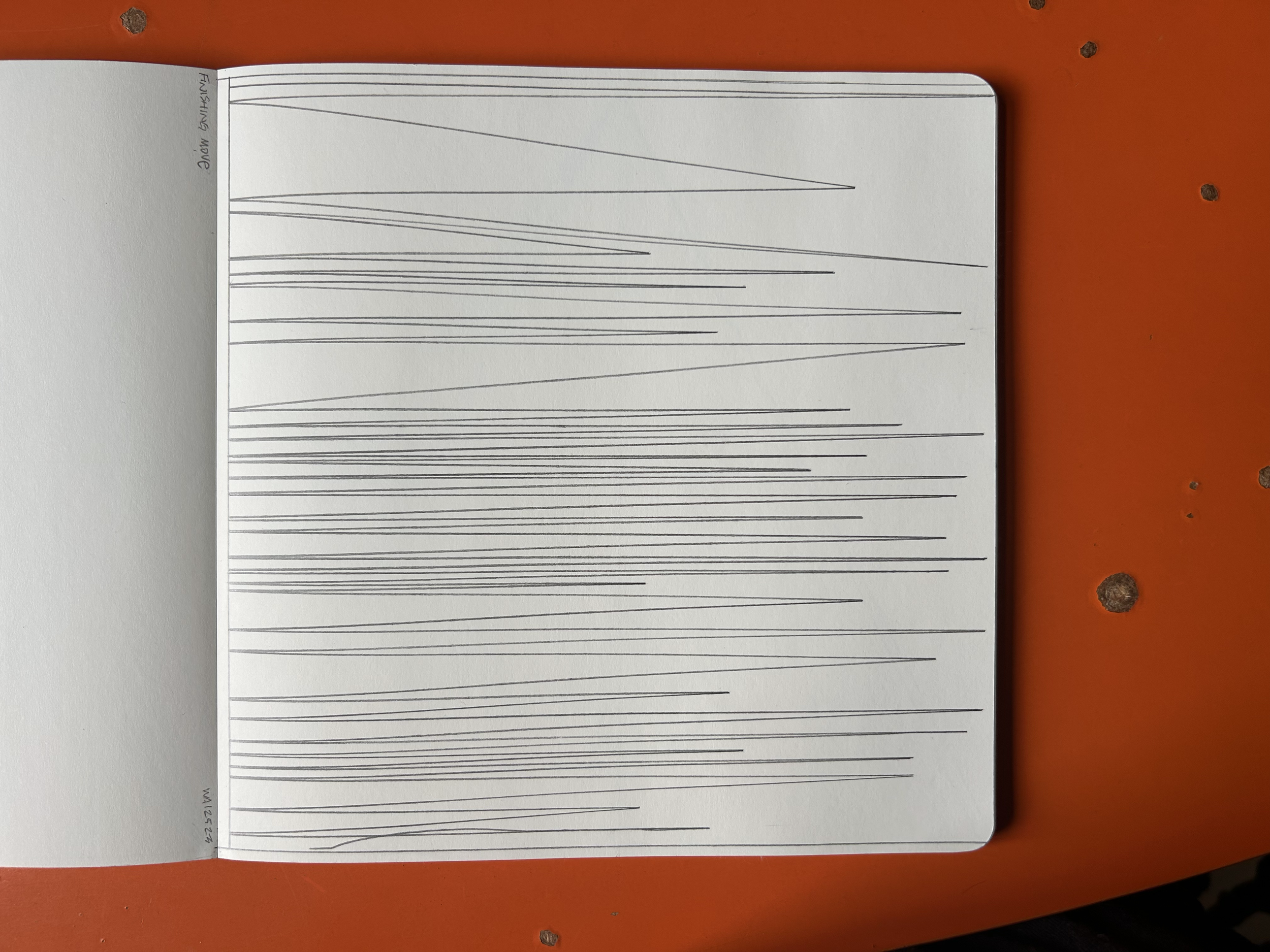Open notebook with various straight black lines drawn on blank white pages, lying on an orange surface.