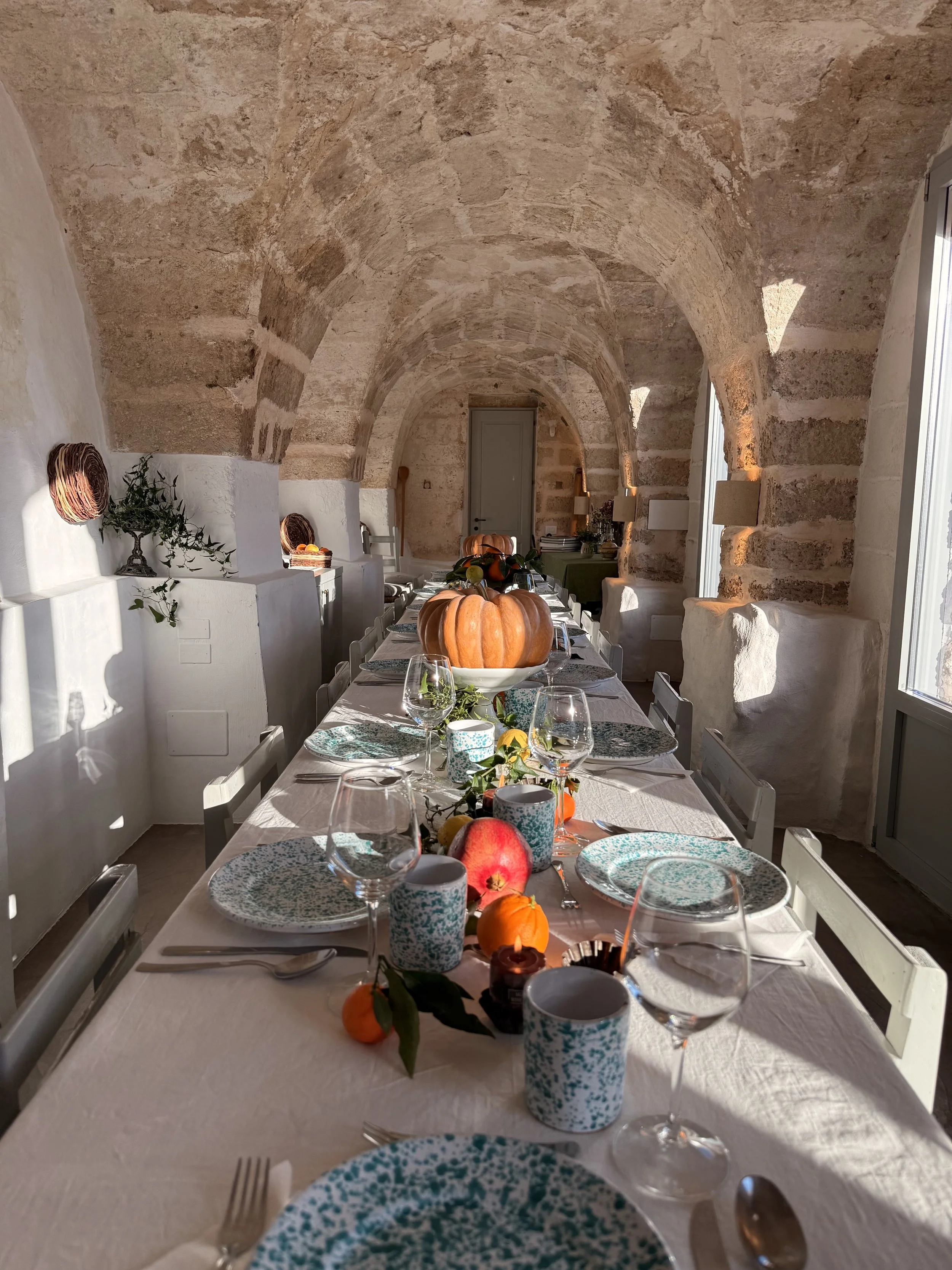 Warmly lit indoor dining room at Masseria Specula during the evening, creating an inviting space for relaxed group meals and retreat gatherings
