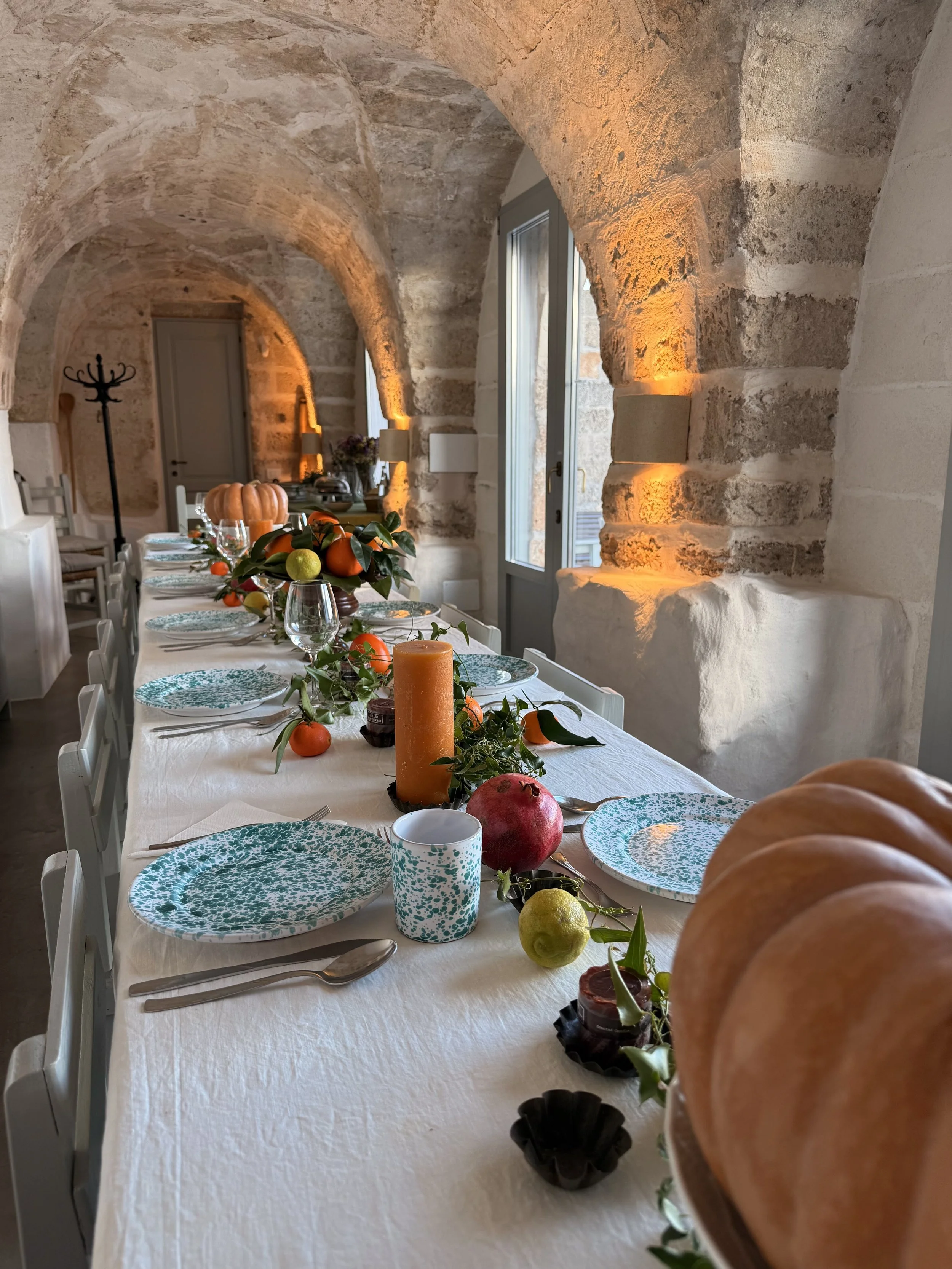 Spacious indoor dining room at Masseria Specula with rustic Apulian architecture, long communal tables, and a warm atmosphere for retreat guests