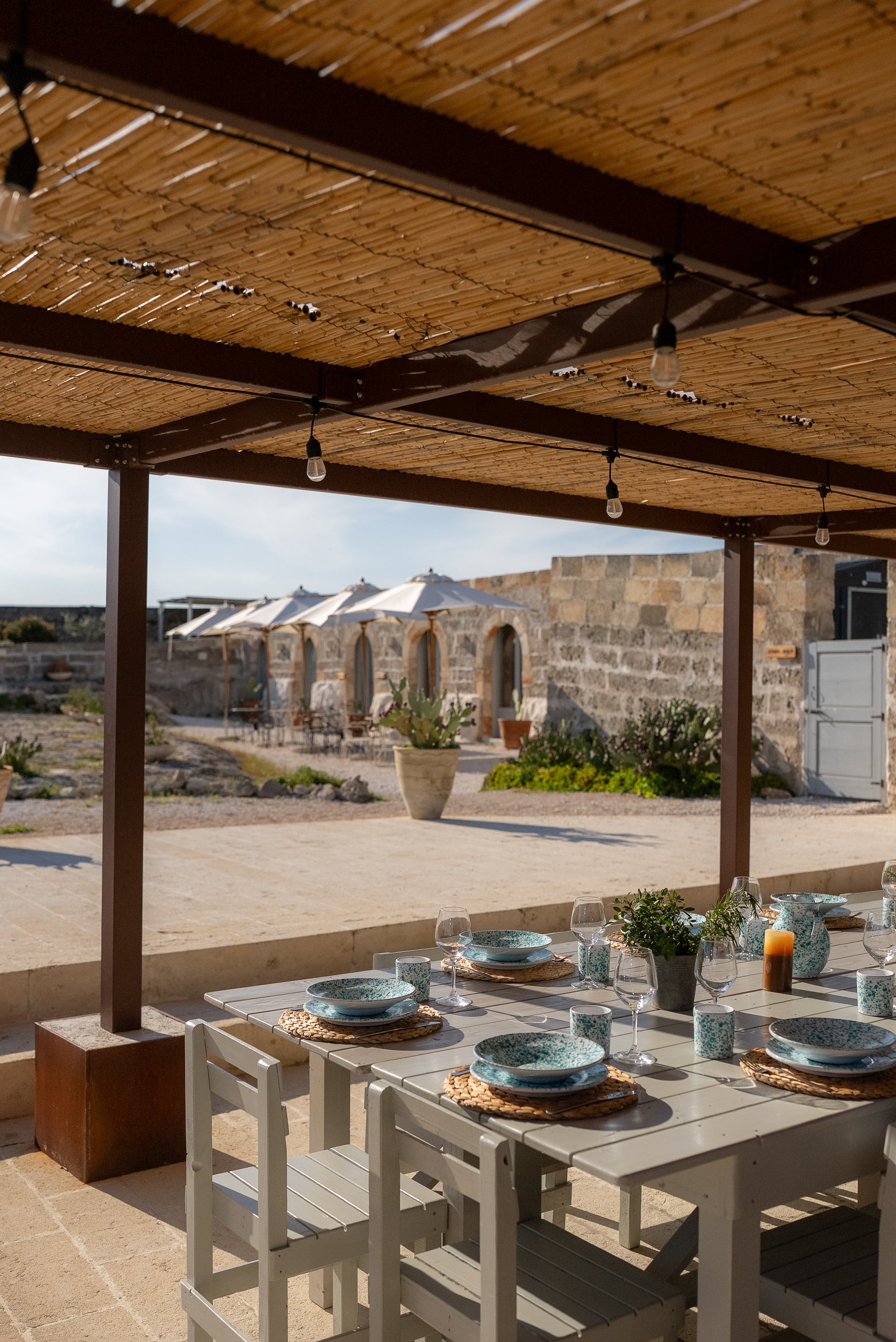 Outdoor dining under pergola at retreat venue in Puglia surrounded by countryside