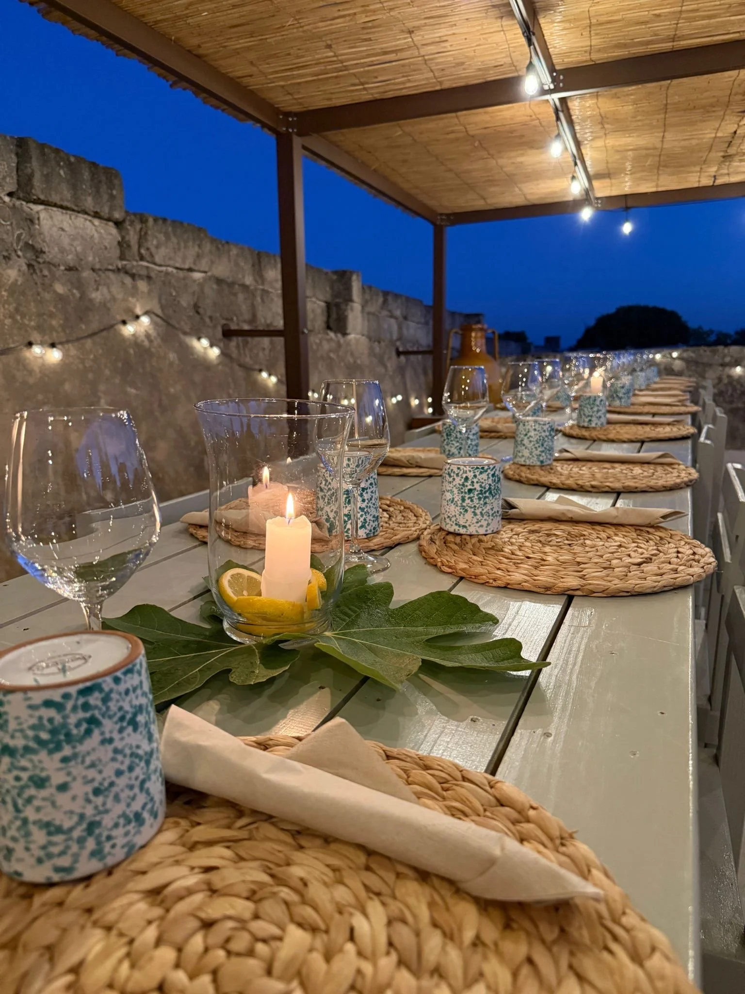 Long communal table set under a pergola at Masseria Specula, ready for shared meals during yoga and wellness retreats in Puglia