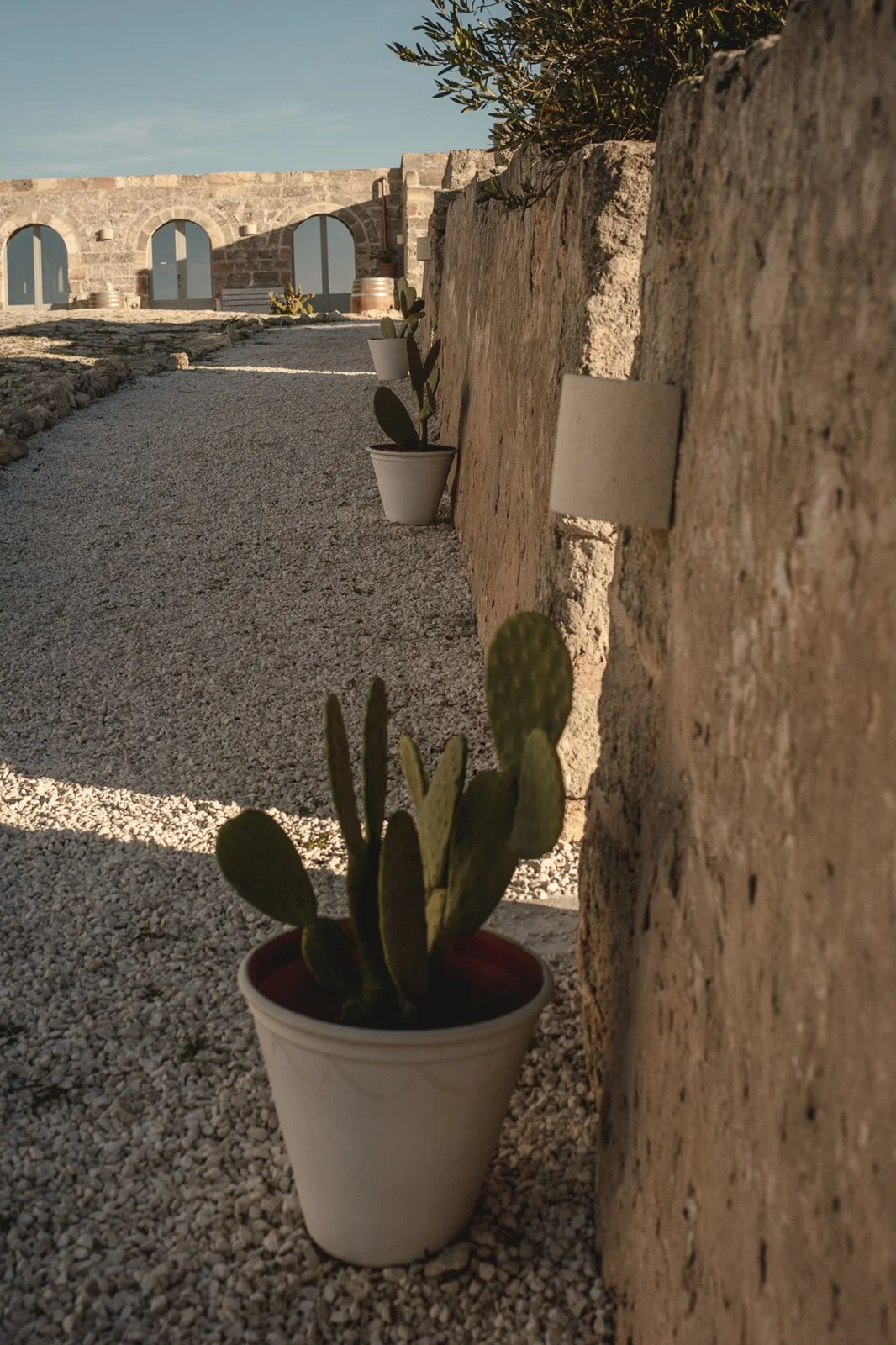 Main courtyard with gravel flooring at Masseria Specula retreat venue in Puglia, Italy