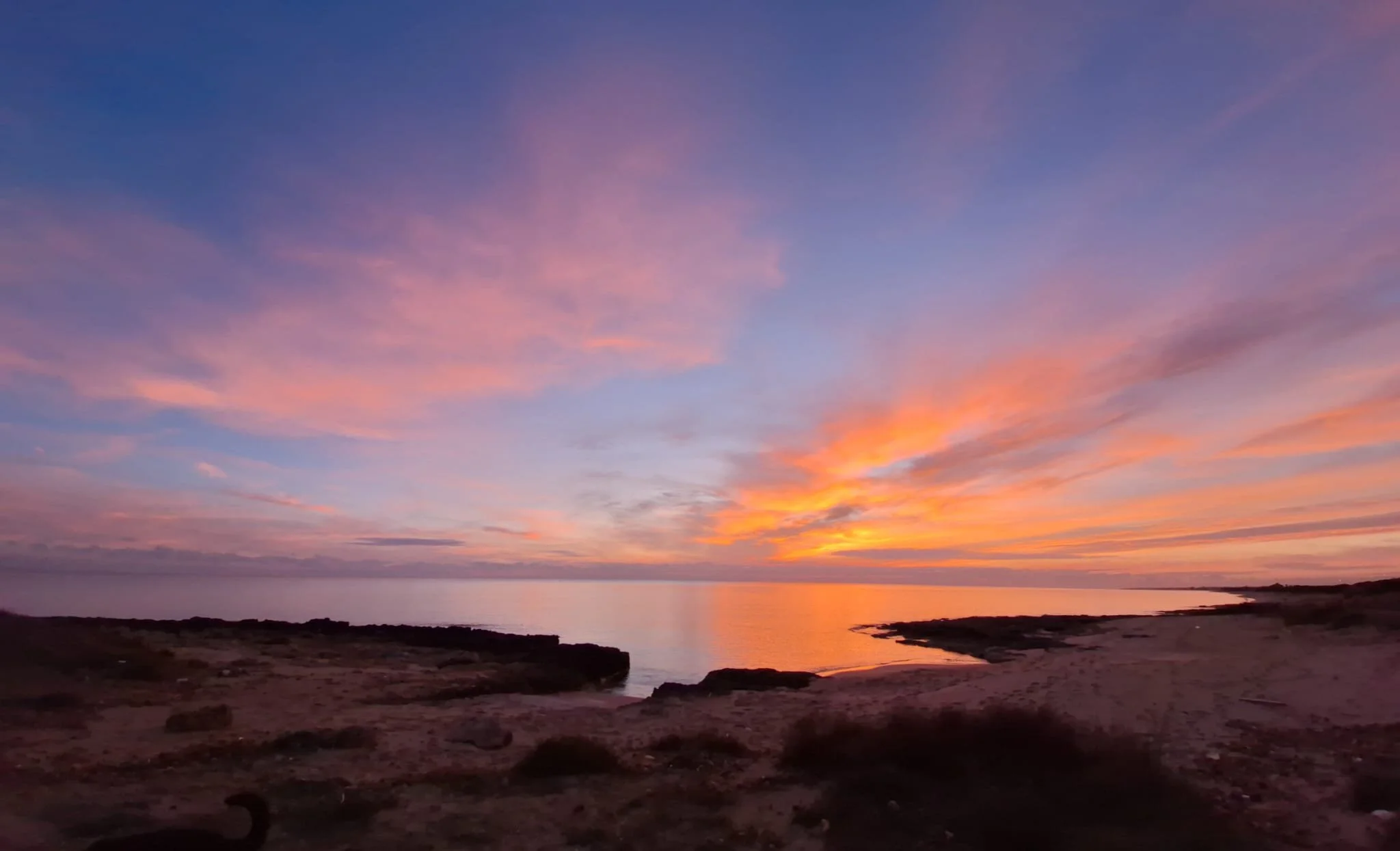 Golden sunset over the beach near Masseria Specula, just a short walk away, offering a serene setting for retreat guests in Puglia