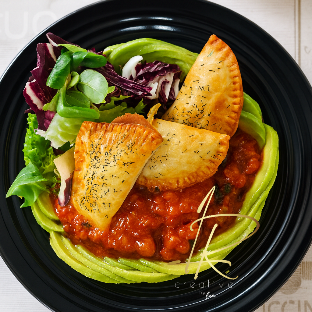 Empanadas vegetales doradas con salsa rústica de tomate y ensalada fresca, creación del chef en el Algarve.