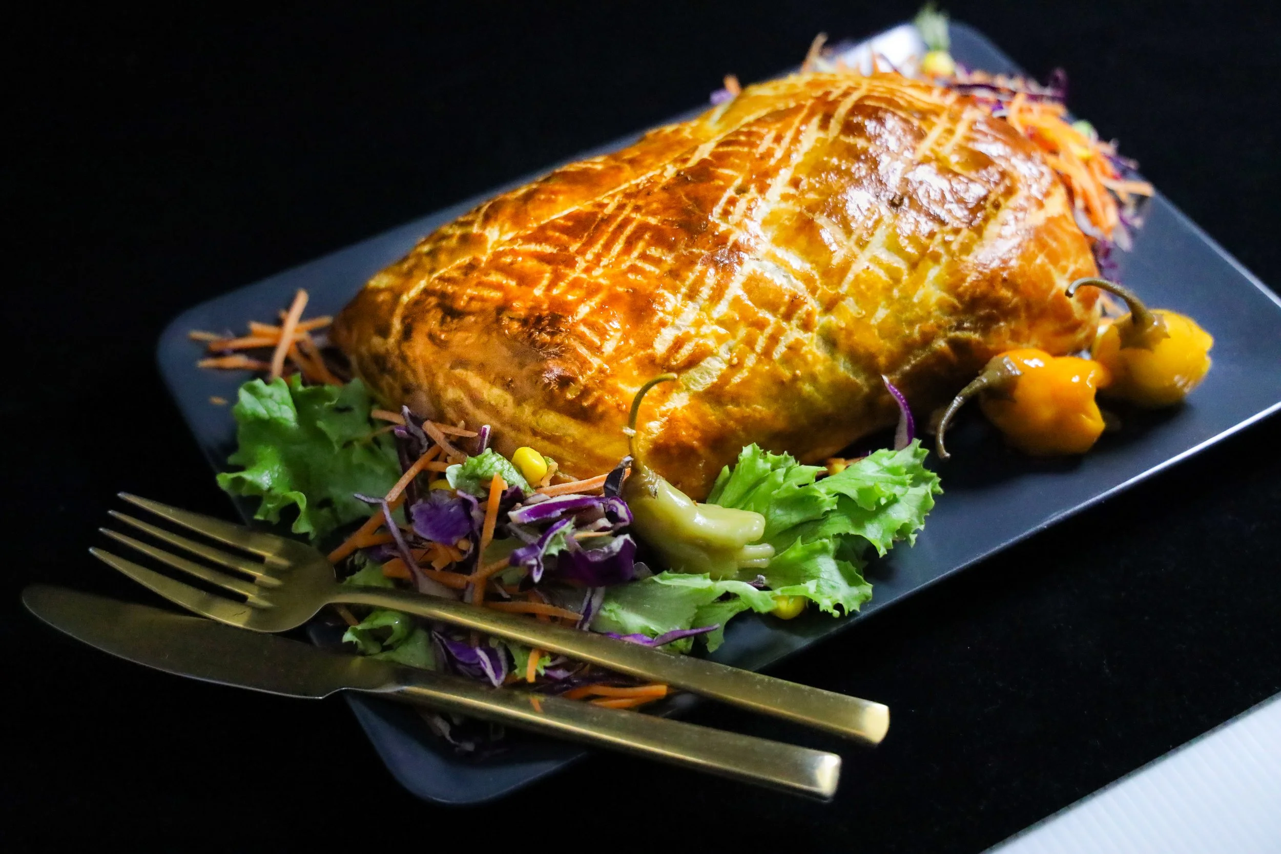 Beef Wellington clásico en hojaldre dorado con ensalada fresca