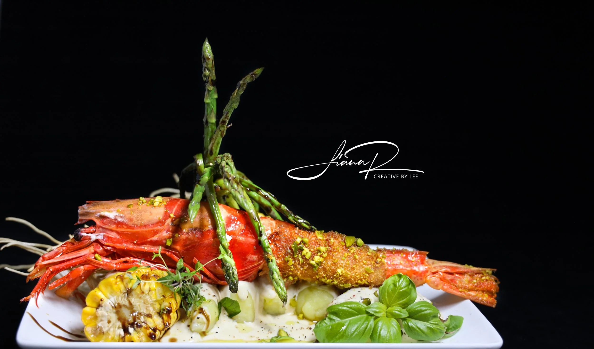 Carabineros a la plancha con ñoquis de trufa negra, salsa de maíz y lima y espárragos, plato gourmet con influencias de la Toscana y el Algarve.