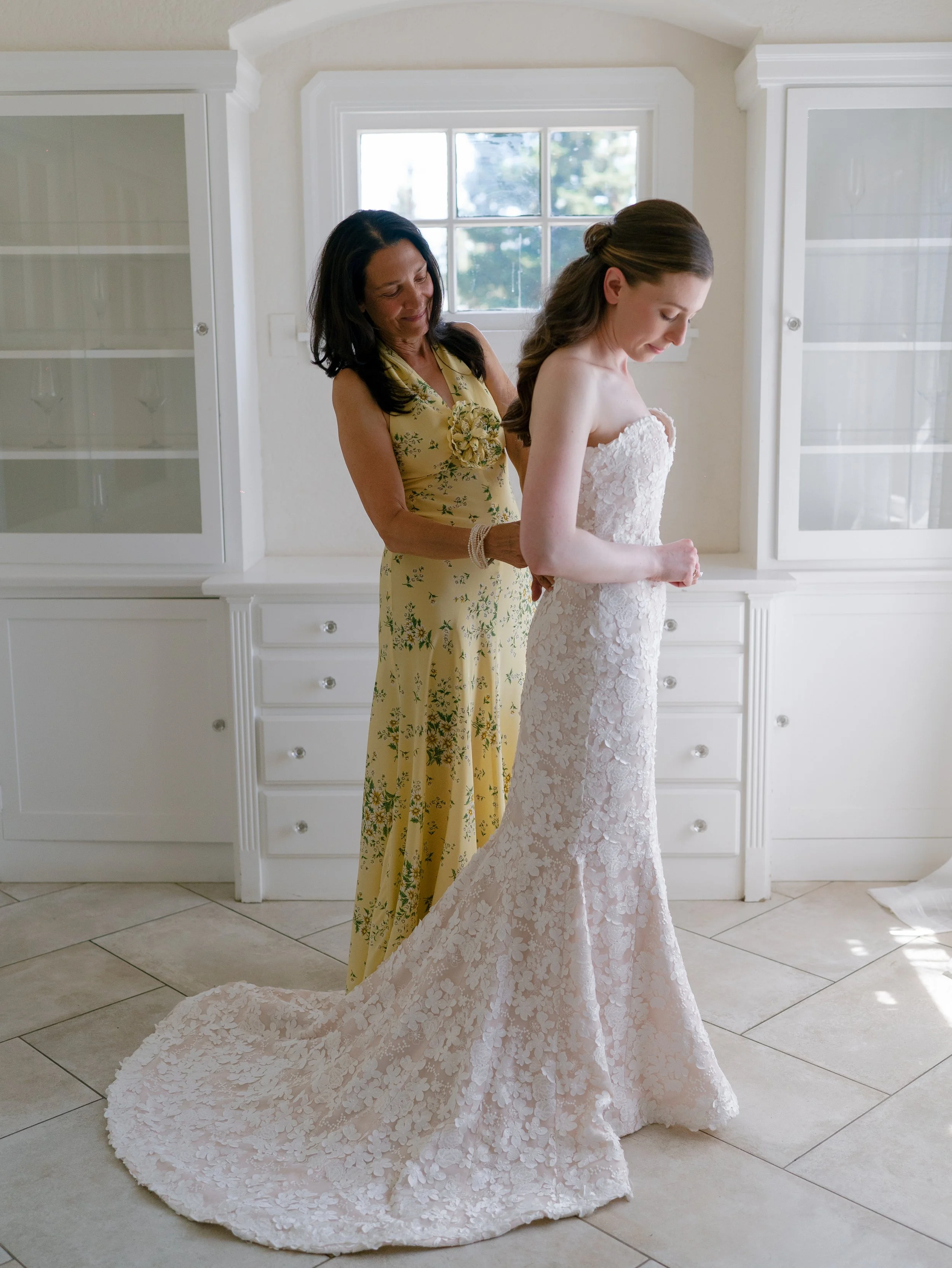 Moment with mother of the bride and bride as she gets dressed in the cottage at Brindare in Saint Helena