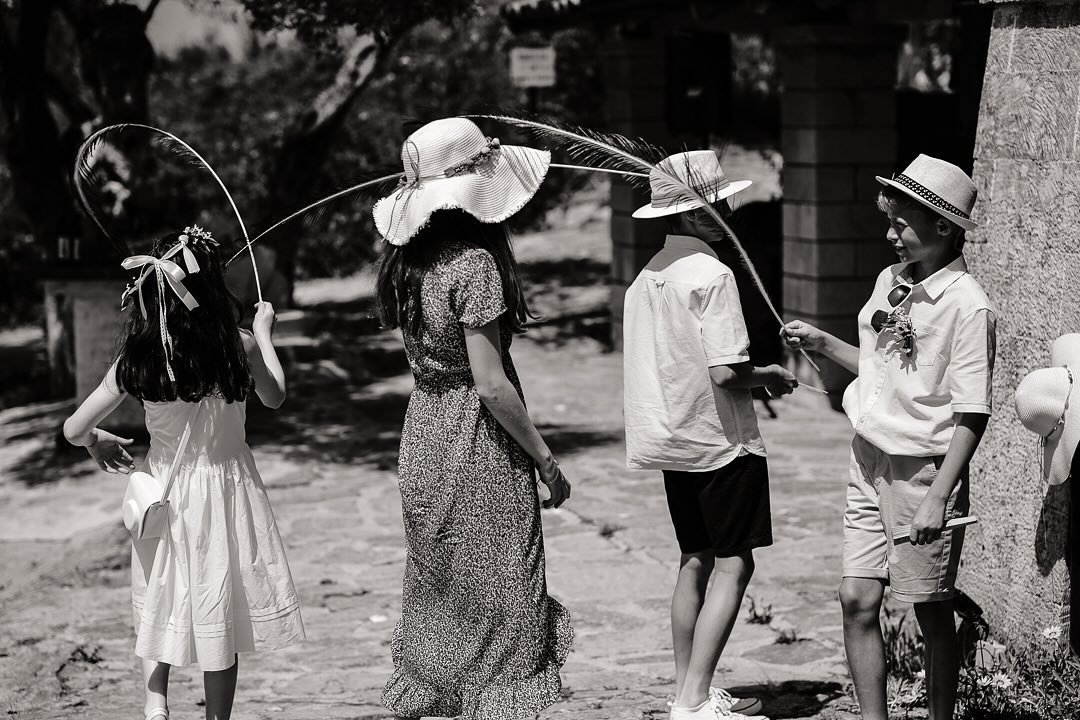 Summer hats &amp; Feathers - kids at weddings inventive in finding their own entertainment. 

#monochrome #blackandwhitephotography #acros #fujifim_xseries #fujixpro3 #xf18mmf14 #fujifilm_hellas #documentaryweddingphotography #weddingphotography #wed