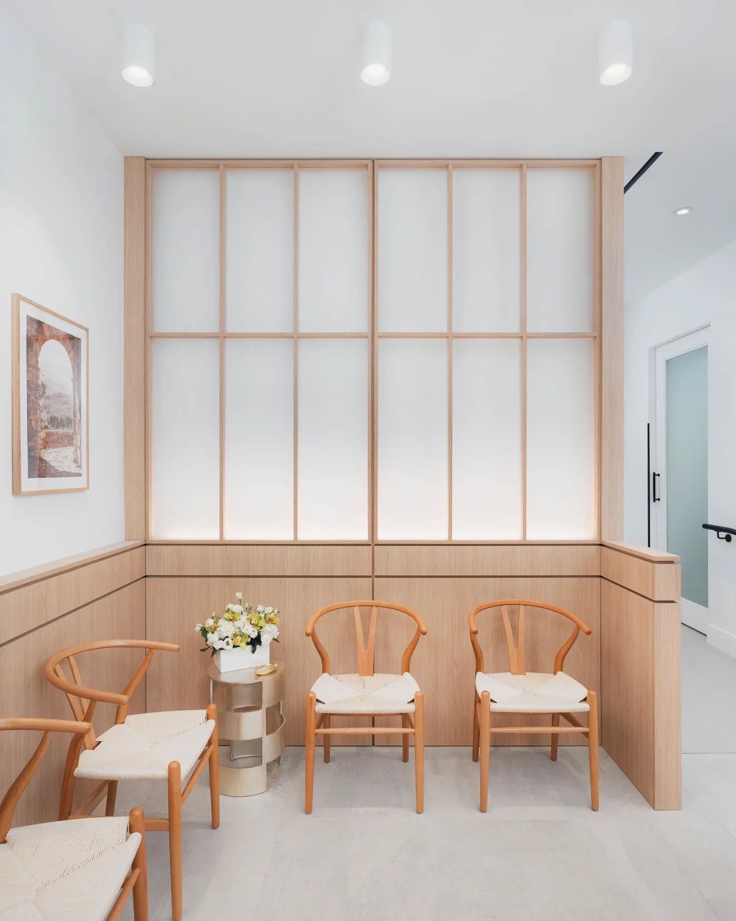 The design of Sovrle Dental uses millwork to create artificial windows that illuminate the space making a small space feel large. The curved reception desk anchors the waiting area and creates a complete focal point together with the light wood cabin