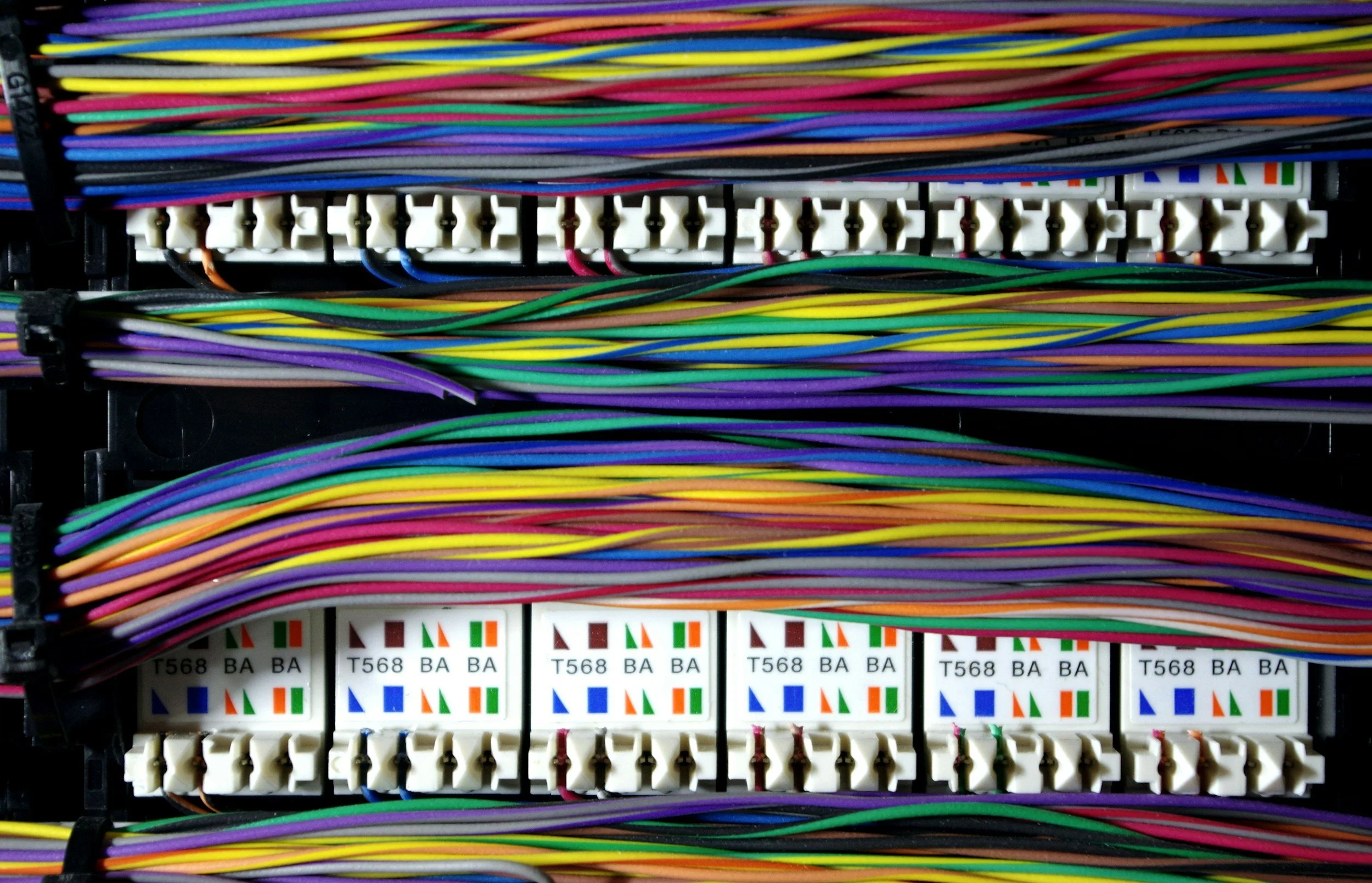 A close-up of a fiber optic patch panel with colorful cables connected to multiple ports.