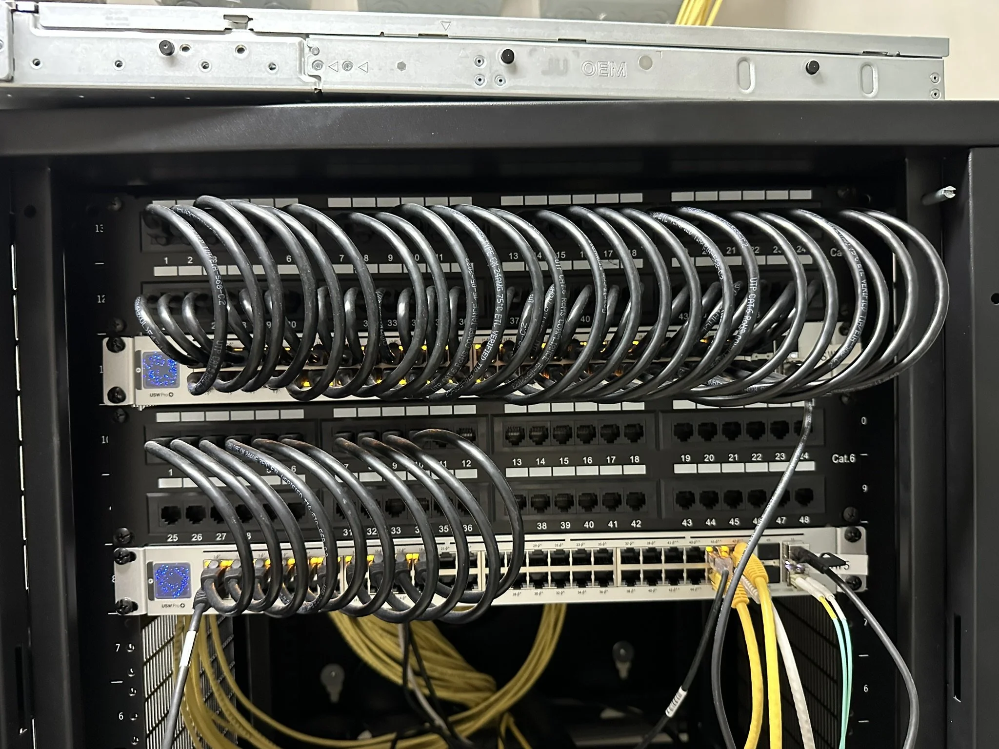 A network server rack with multiple Ethernet cables connected to various ports, organized in a structured manner.