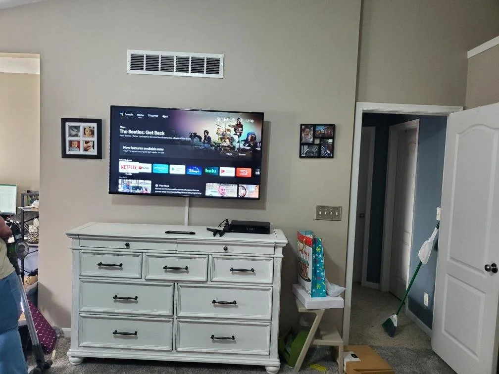 Home theater system installed above a dresser, with the cords neatly hidden by cord covers.