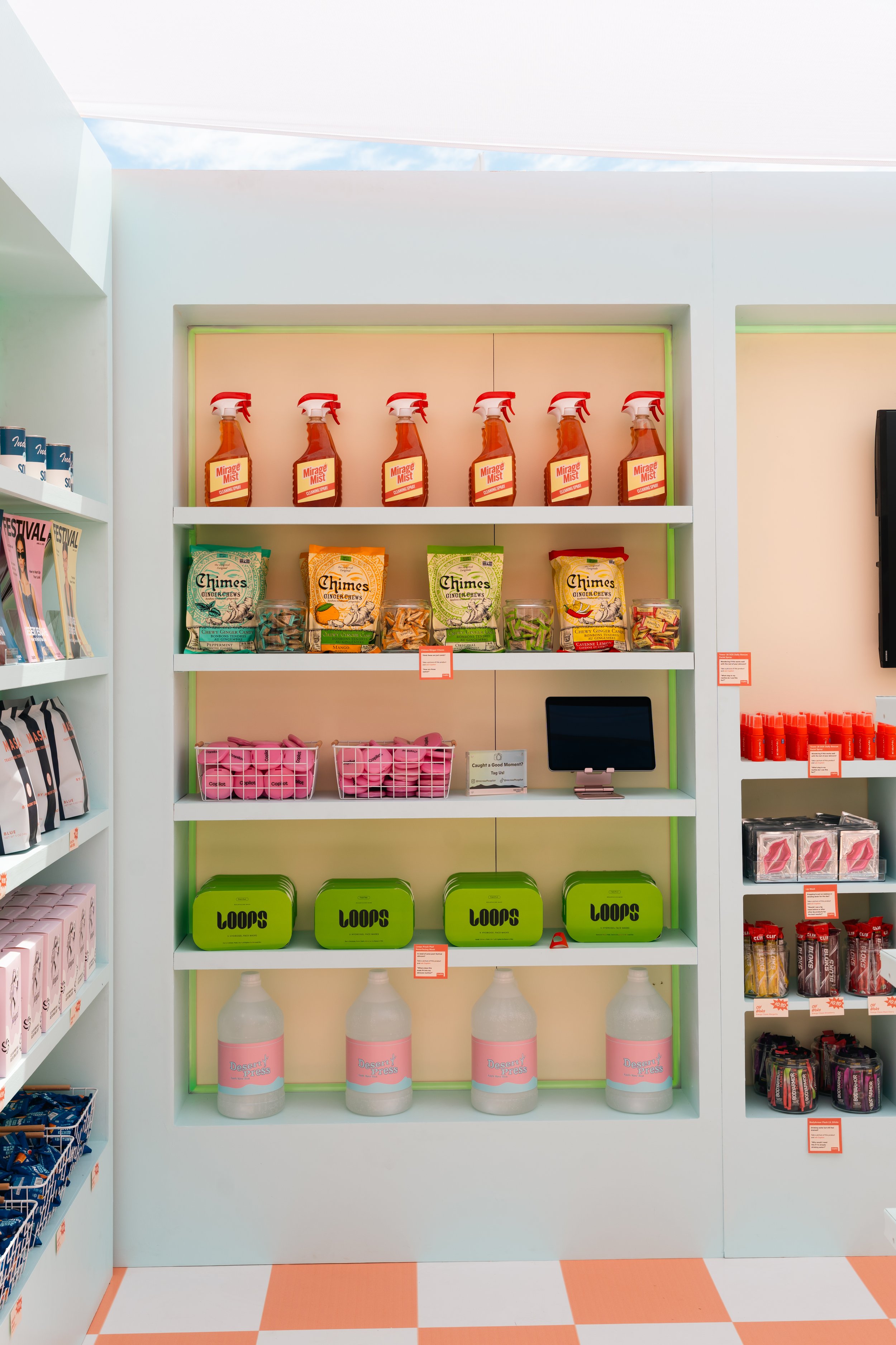 Store shelves displaying various products including cleaning spray bottles labeled 'Miracle Mist,' bags of 'Chimes' ginger chews, containers labeled 'Loops,' pink boxed items, and large bottles of 'Dragon's Tears.'