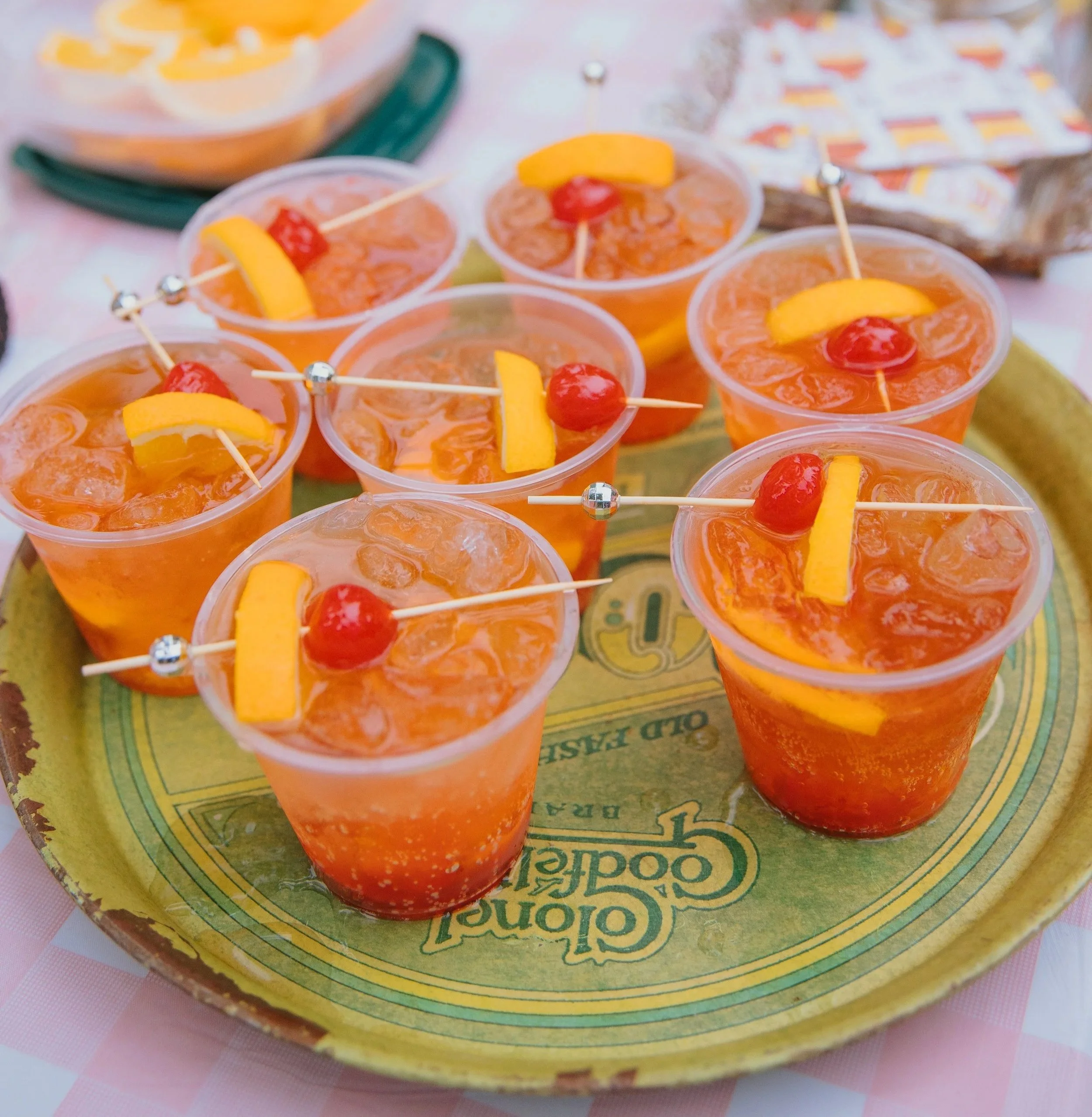 Tray of Berens Old Fashioned brandy cocktails with orange slices and cherries on vintage golden tray at Camp Lola Whiskey Wisconsin