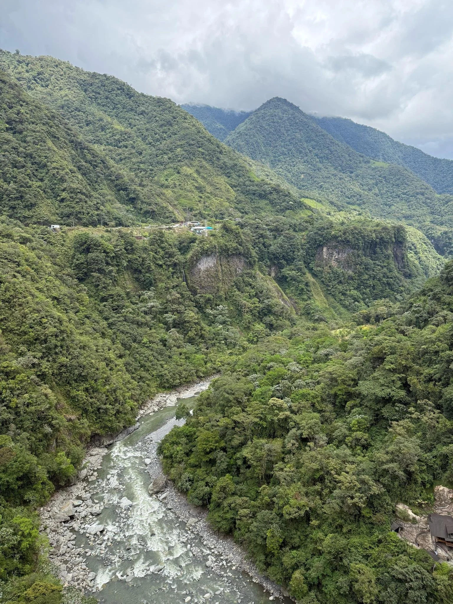 Lush green river valley and mountain landscape in Baños, Ecuador