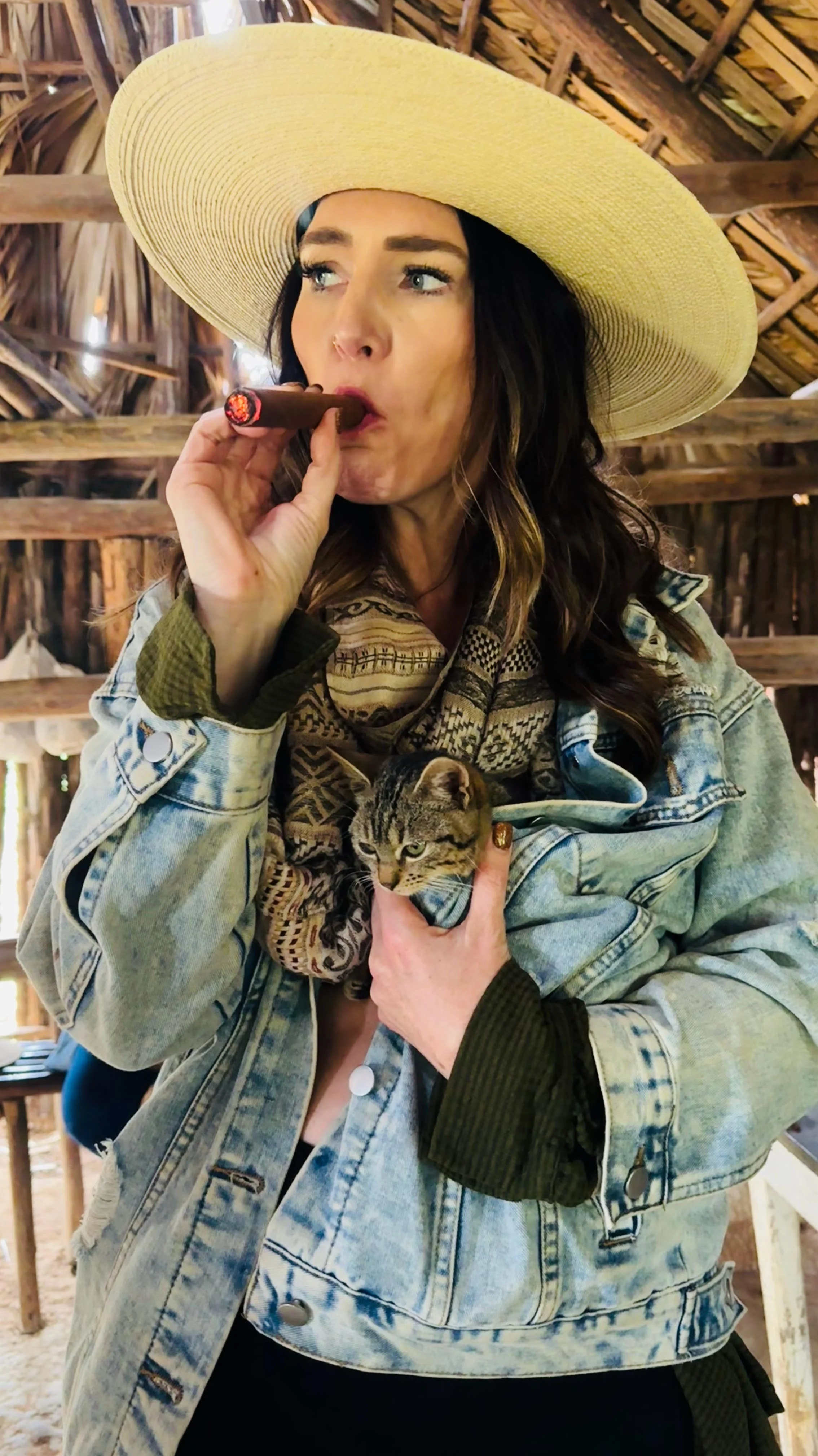 Laura Ericson holding a street kitten while smoking a cigar in Viñales, Cuba