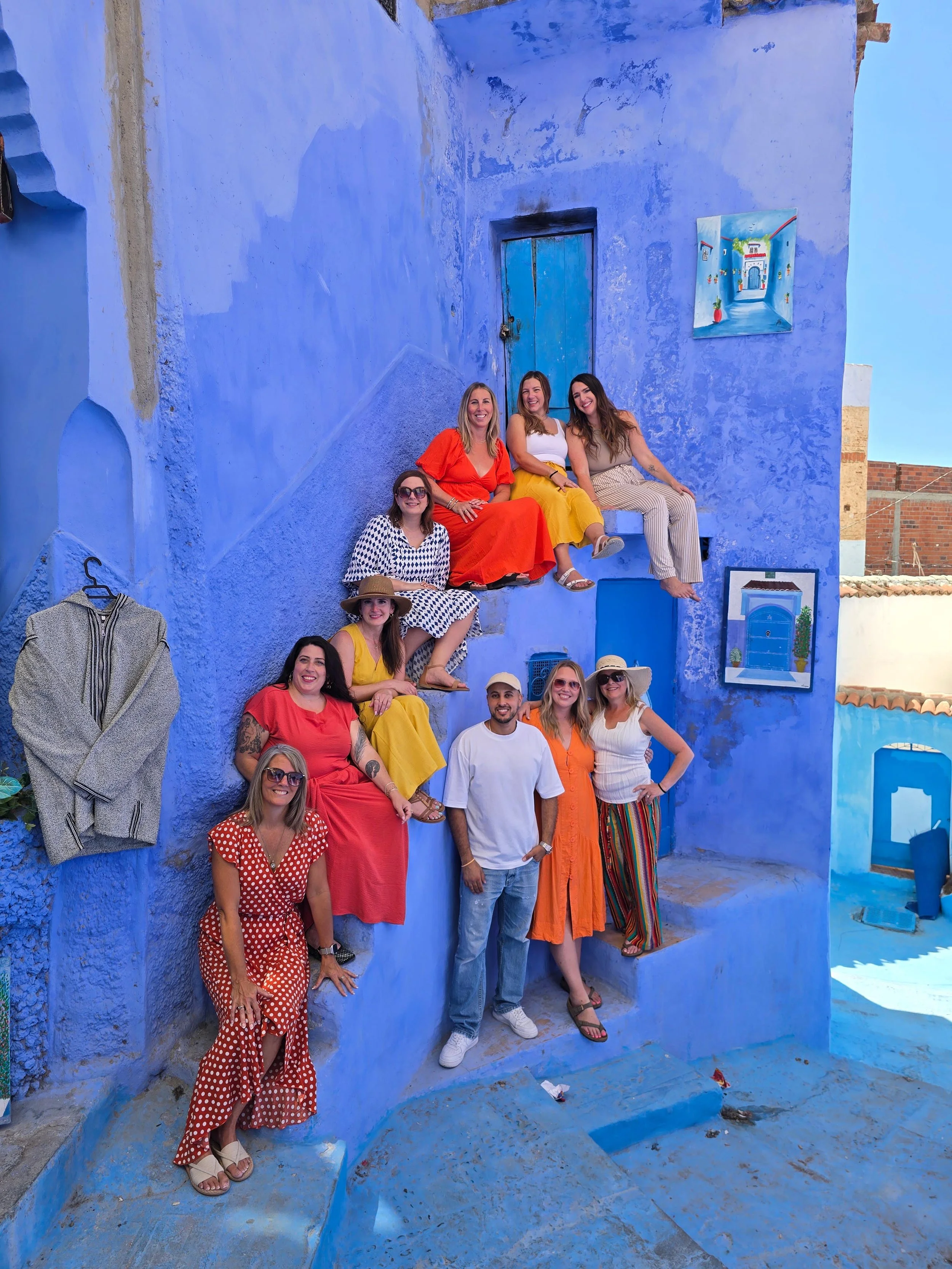 Laura Ericson group trip travelers posing on the blue steps of Chefchaouen, Morocco