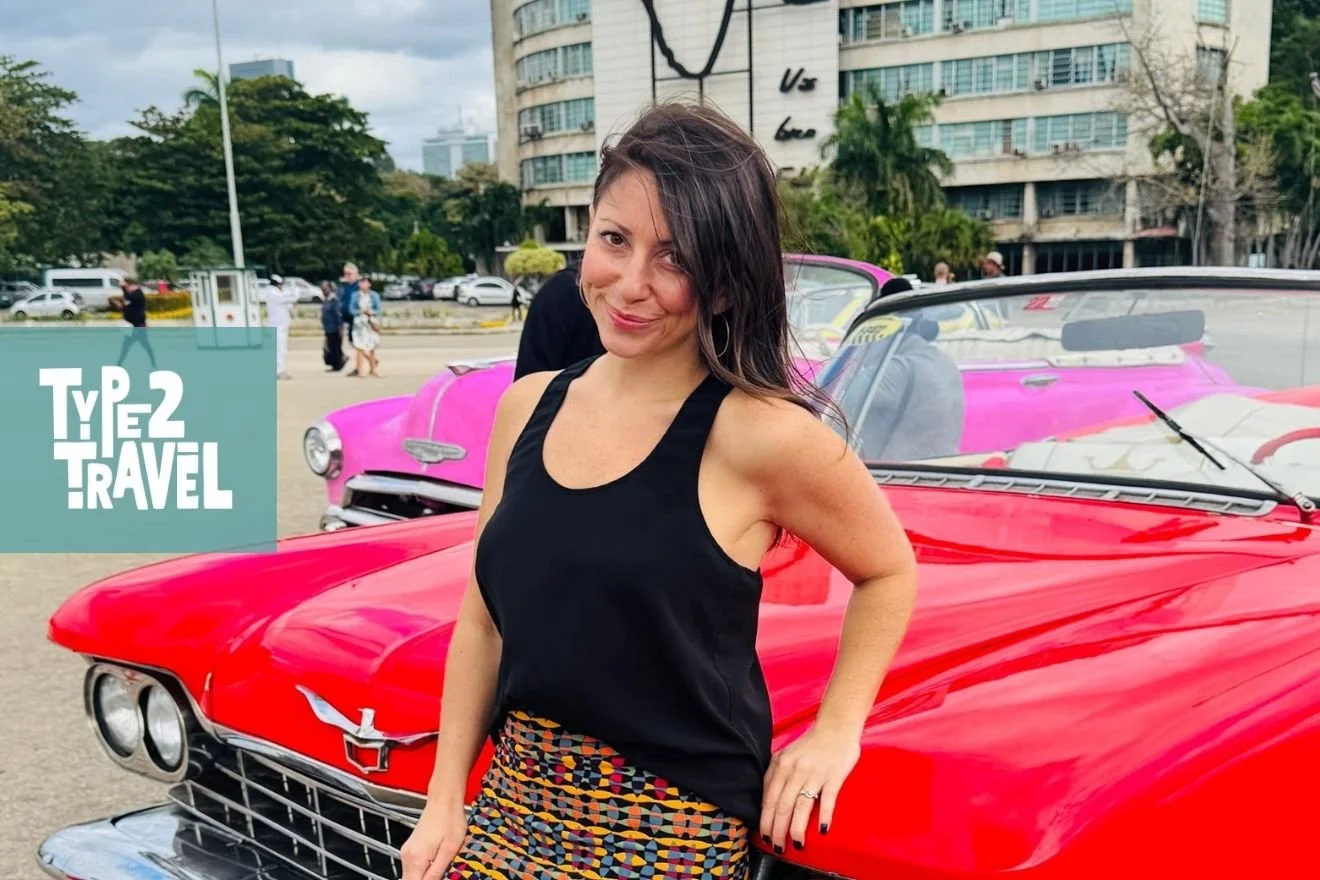 Type 2 Travel podcast guest Dawn Mullarney standing next to vintage pink classic car in Havana Cuba