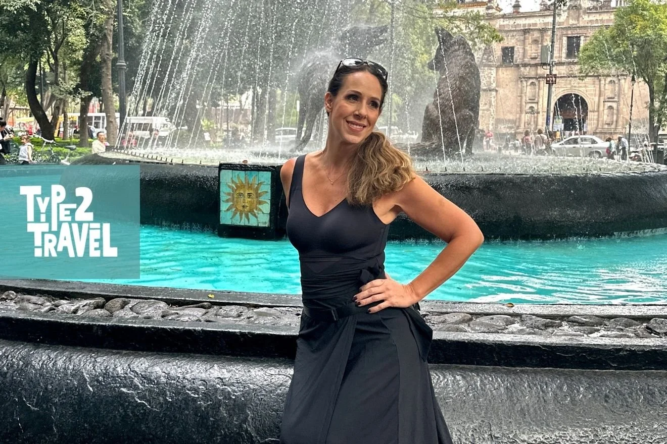 Woman in black dress standing by turquoise fountain with historic building backdrop and Type 2 Travel podcast logo