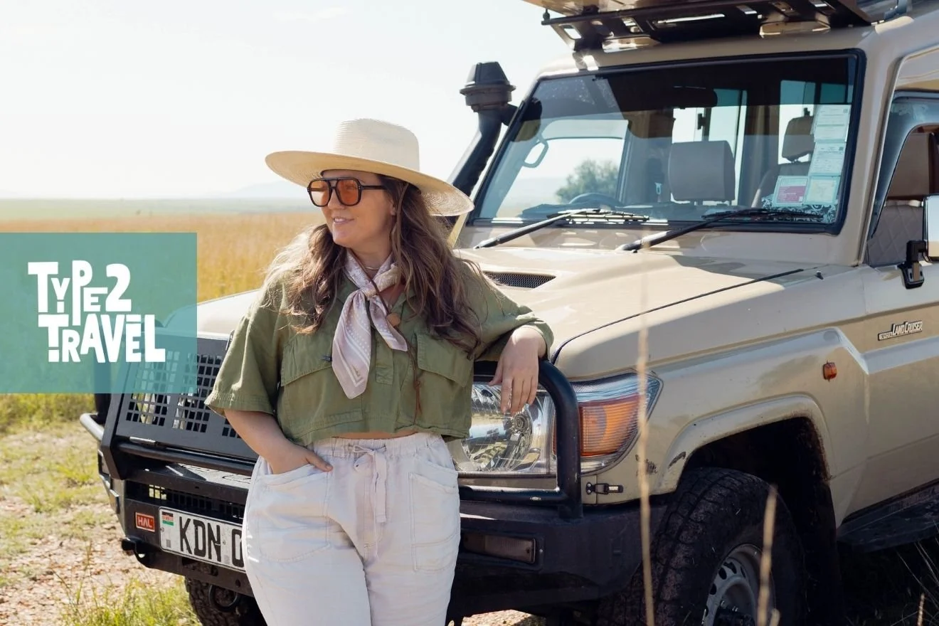 Allie Jorde in safari outfit leaning against Land Cruiser in African landscape with Type 2 Travel podcast logo