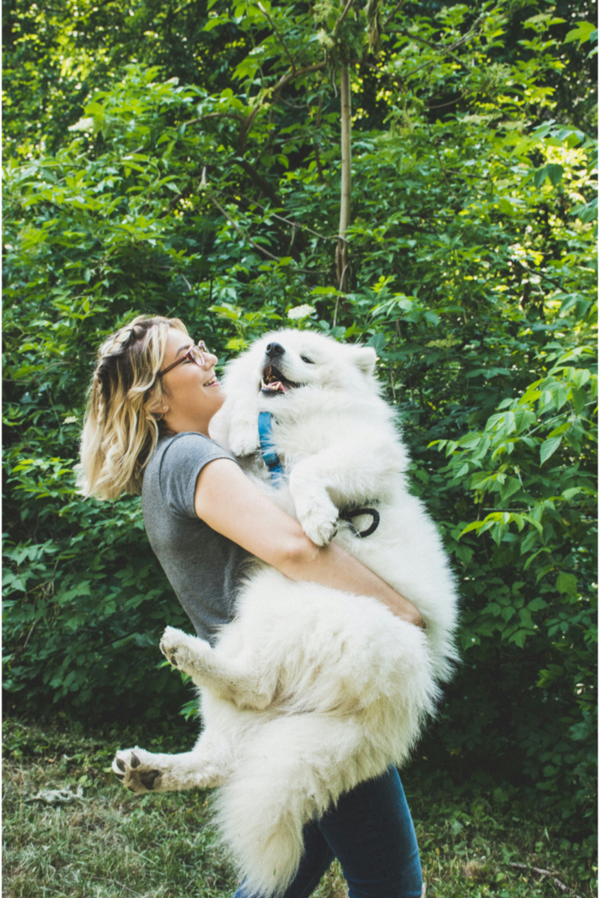 Woman holding a big white dog