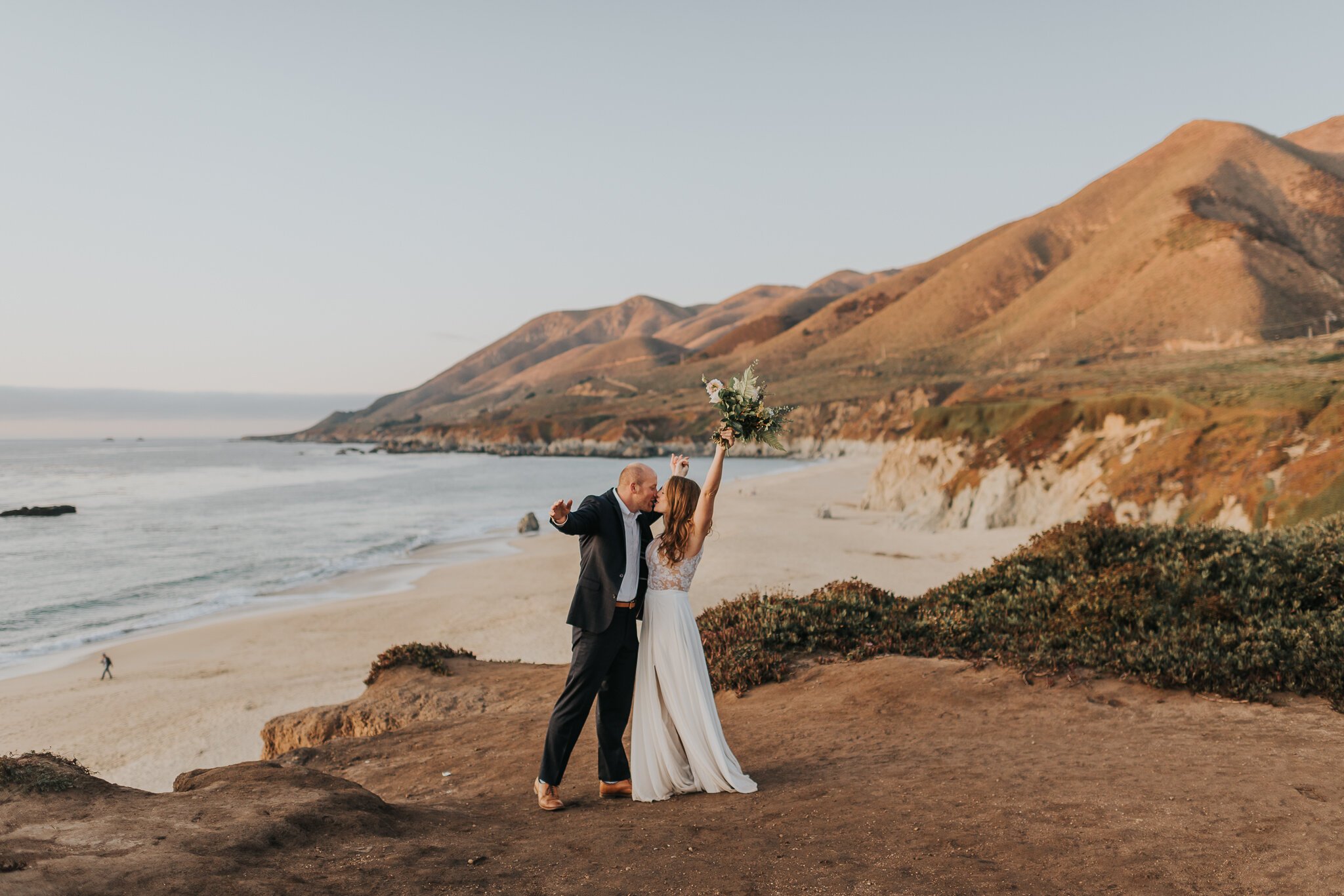 Big Sur Elopement newly married on the cliffside kissing after vows