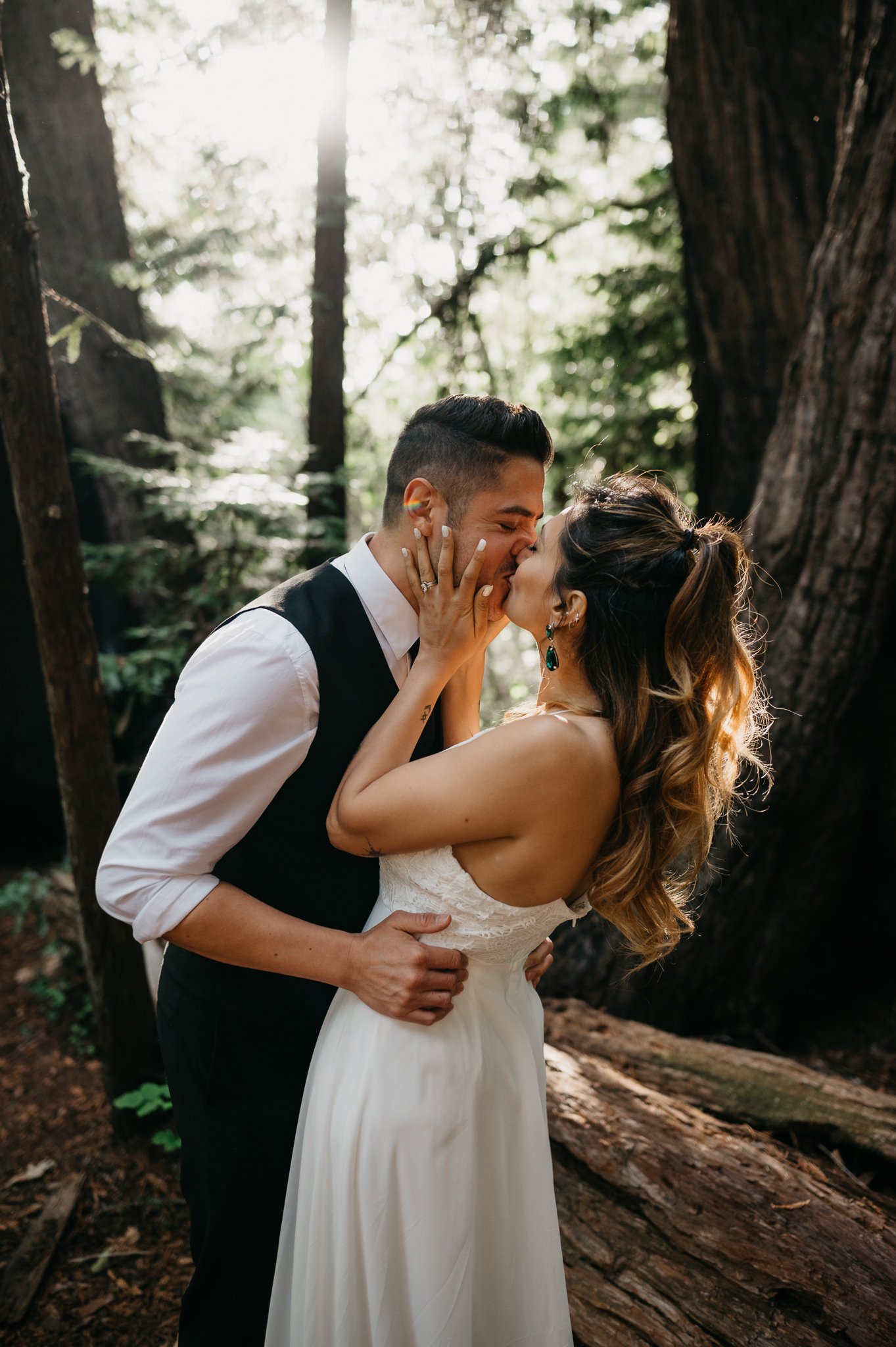 newly married couple kissing beneath redwood trees in Big Sur California