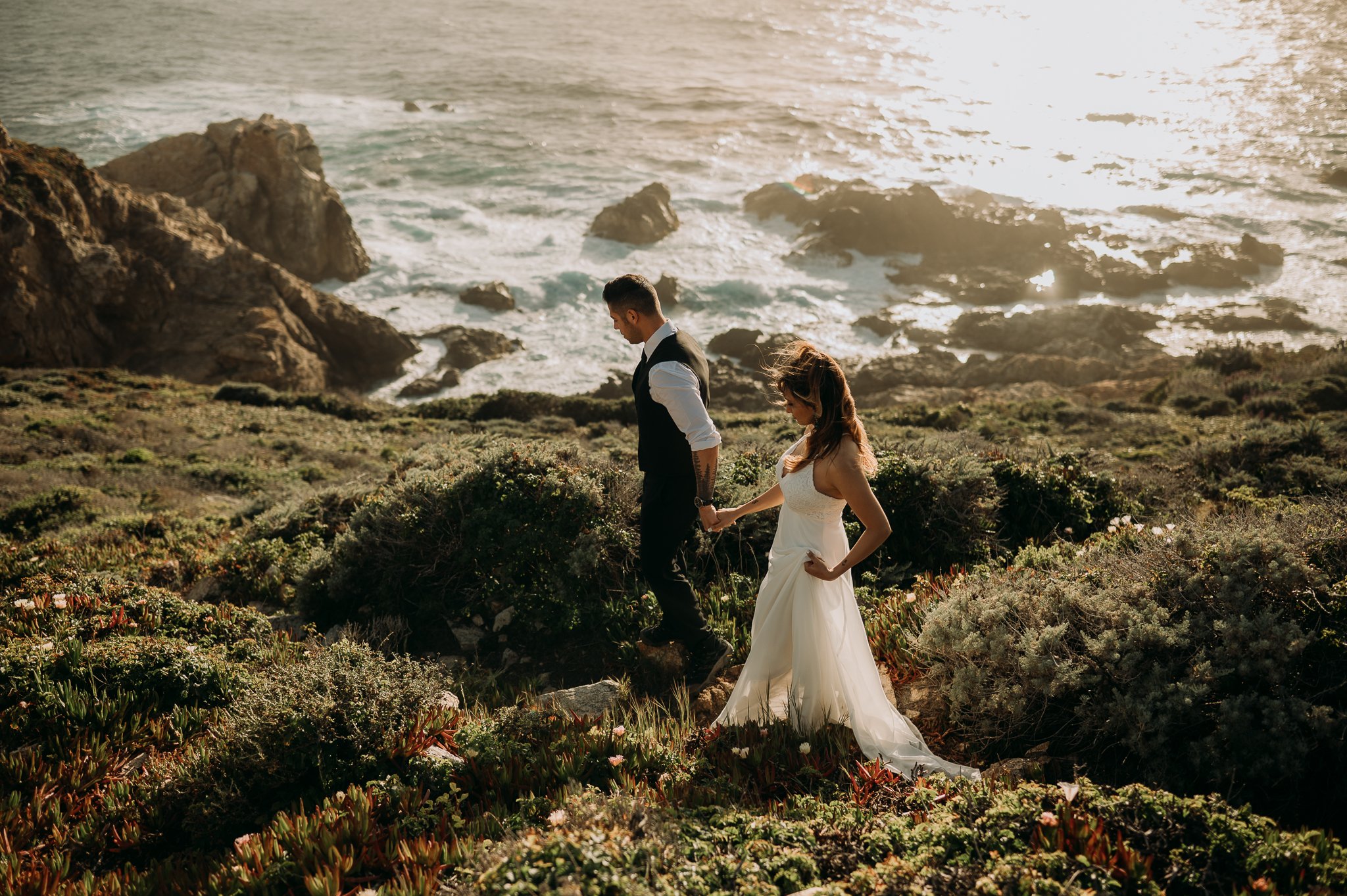 Post wedding photo session cliffs of Big Sur couple walking on trail at sunset