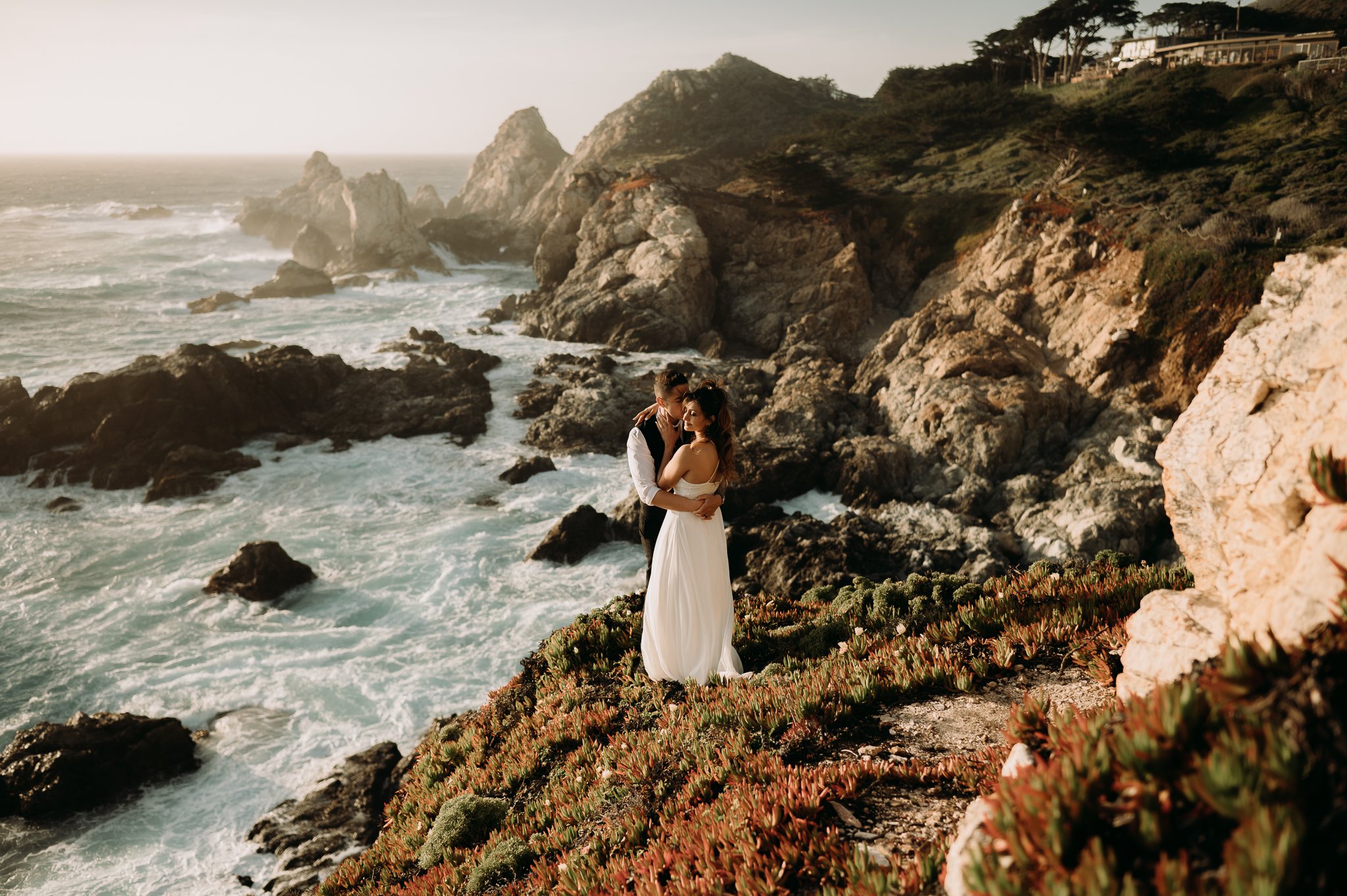 Couple embracing on trail above Pacific Ocean Big Sur