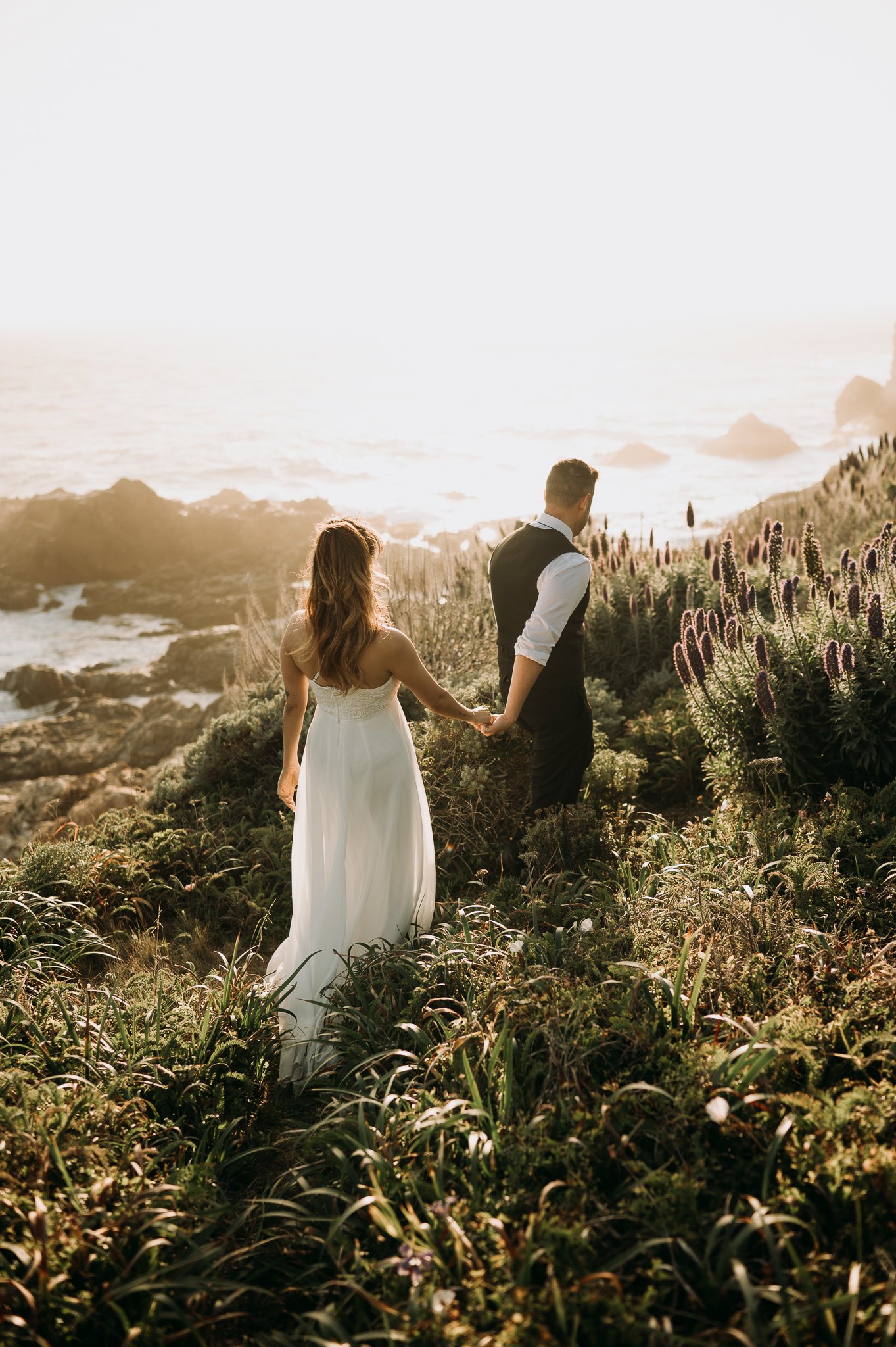 Couple posing on trail above Pacific Ocean Big Sur