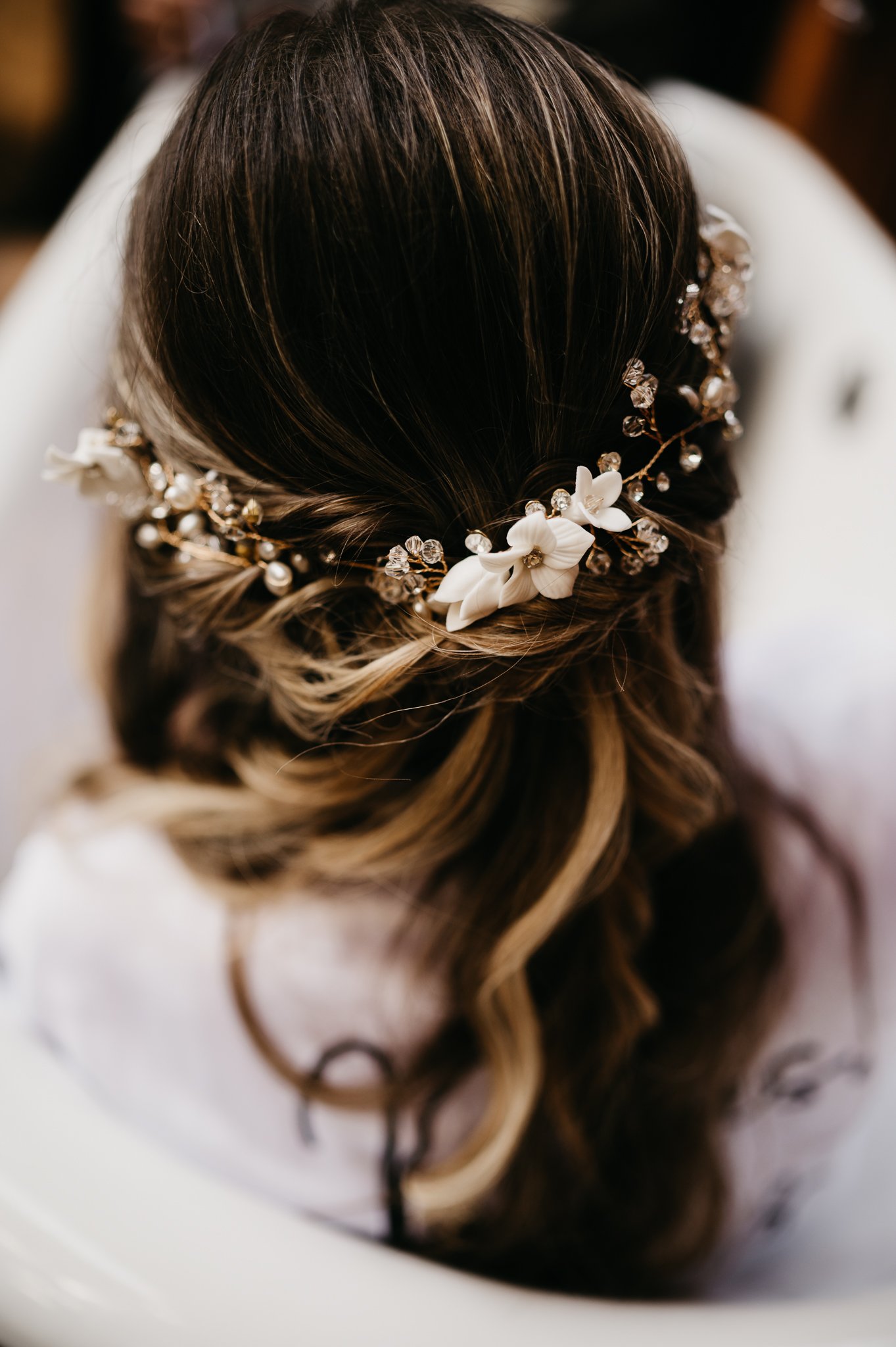 Brides long brown hair with sides pulled back with flowers intwind in hair