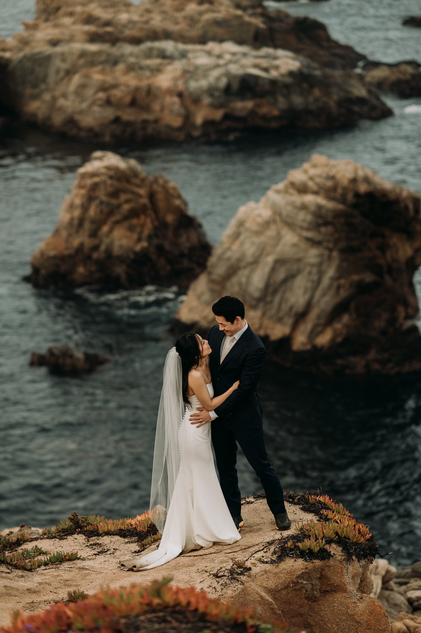 elopement bride and groom embracing cliffside Big Sur