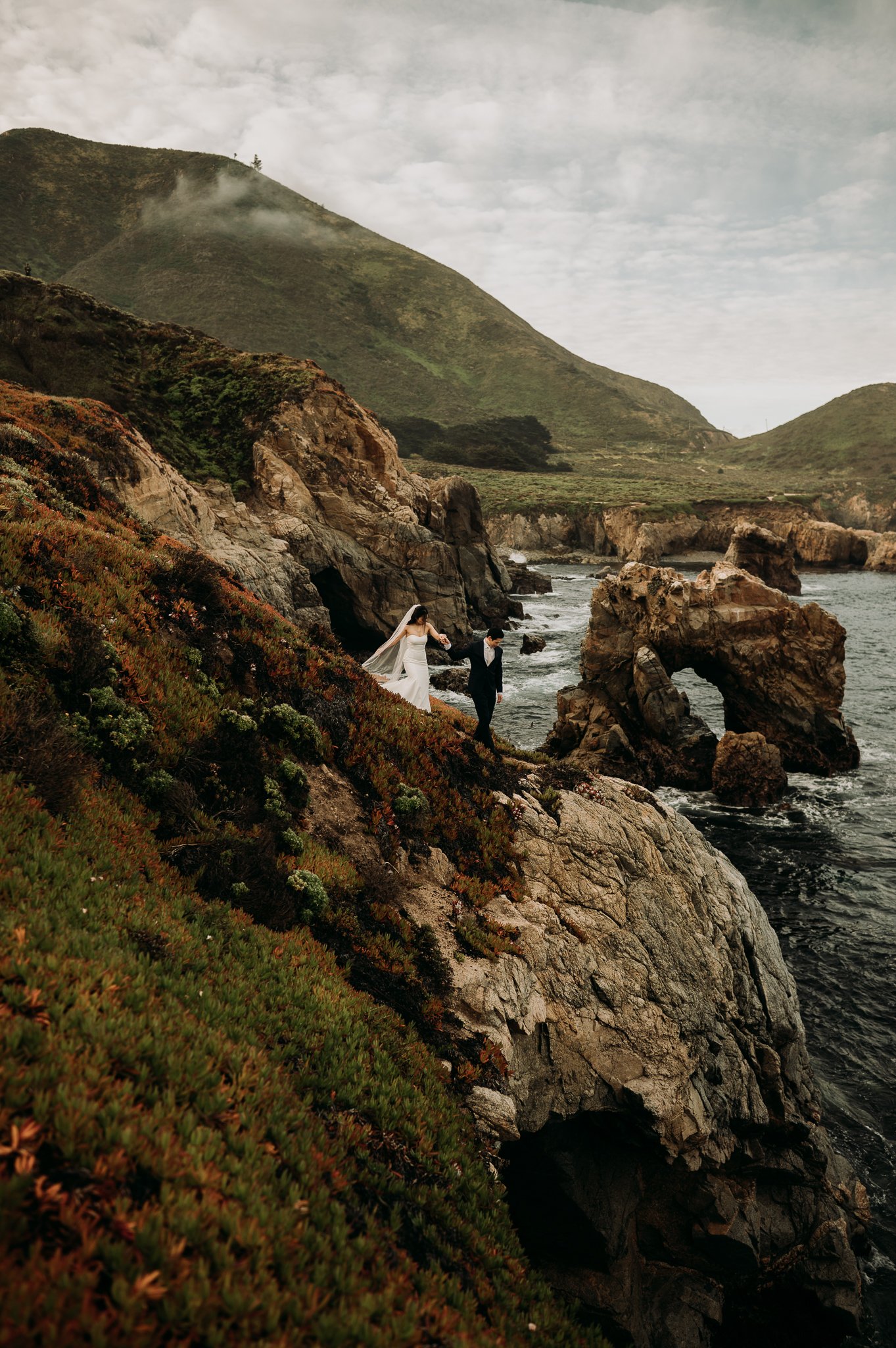 Elopement couple cliffside Big Sur with key hole rock in background