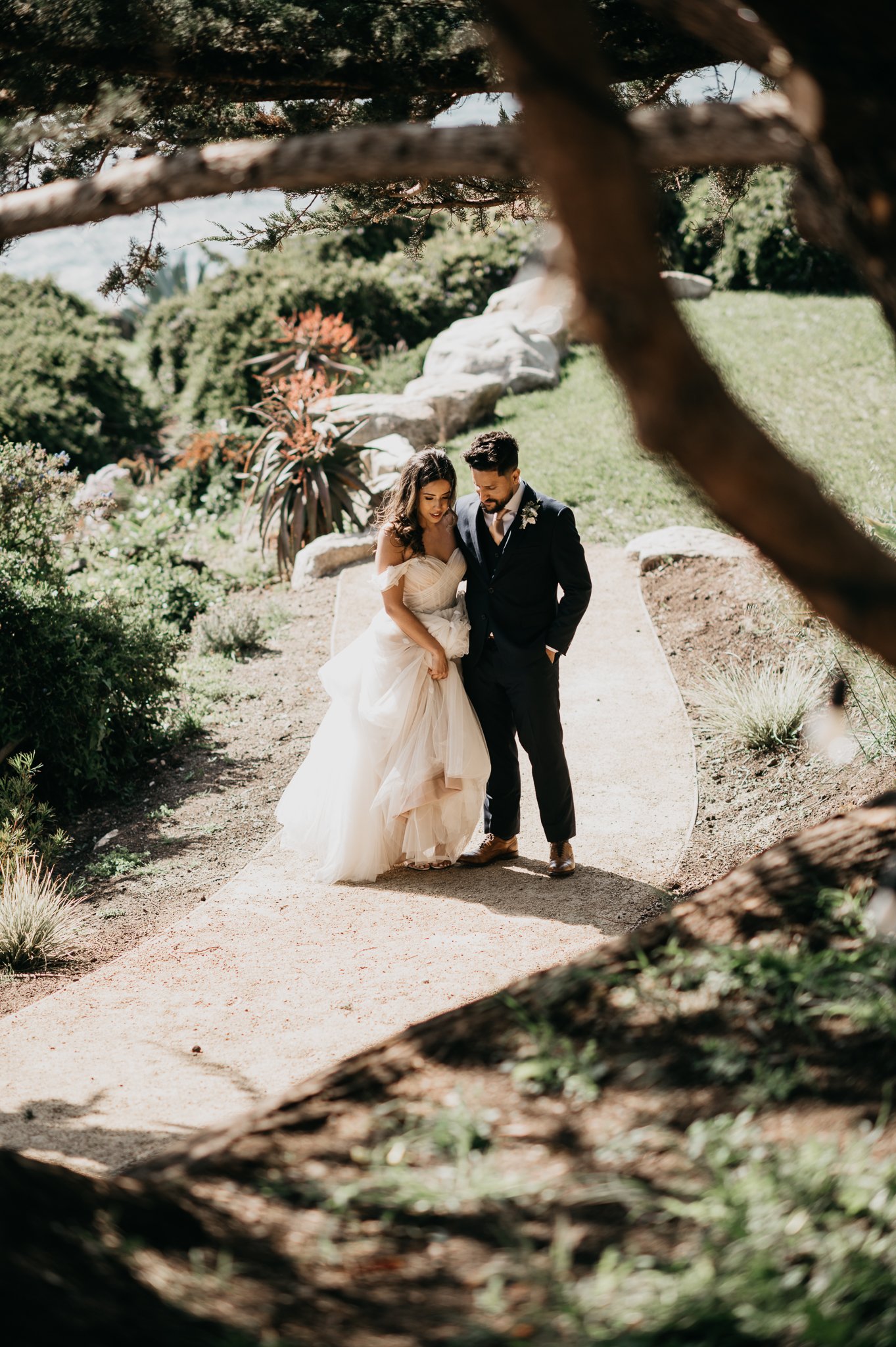 bride and groom share a private moment on garden path after ceremony