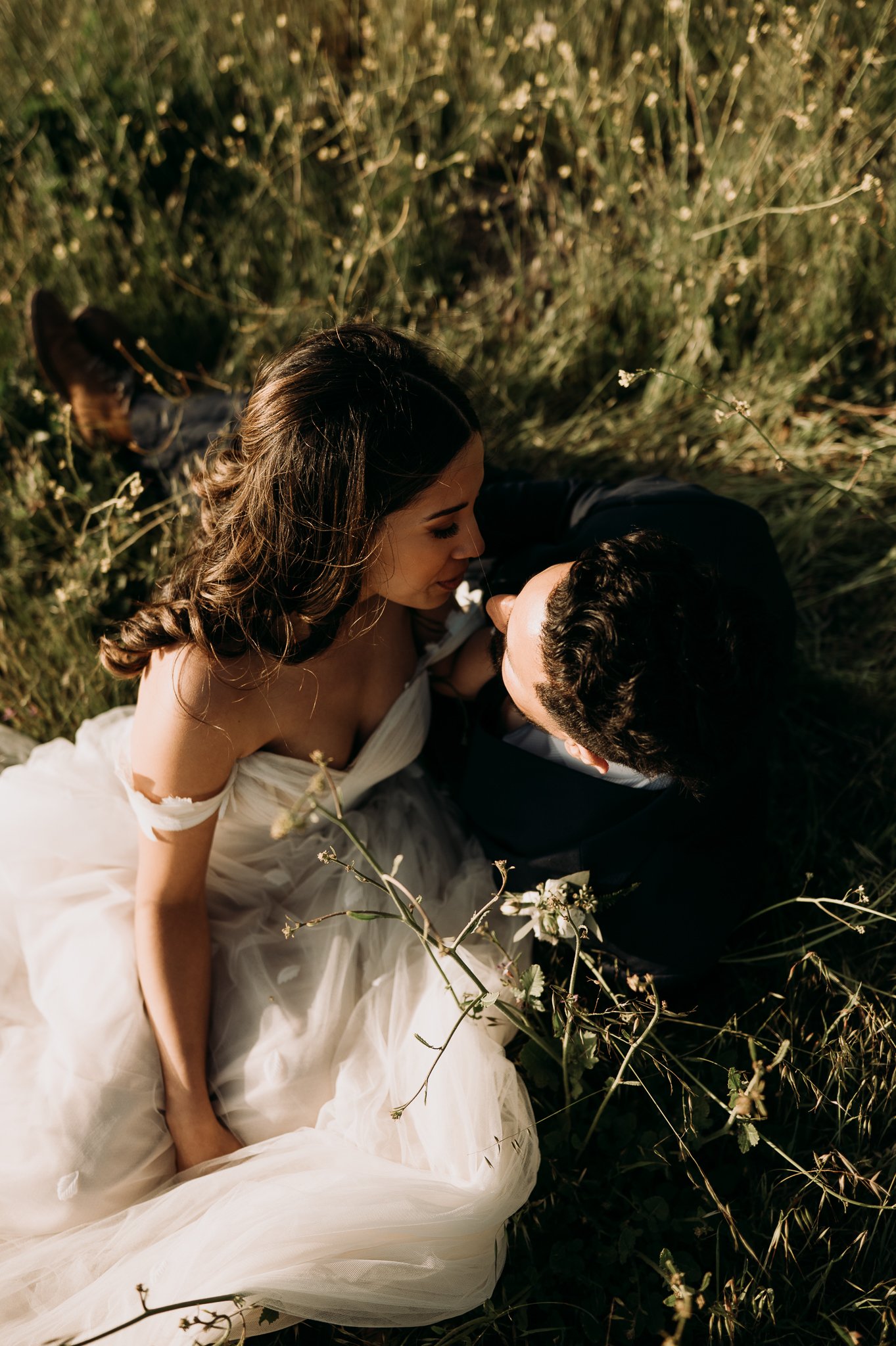 newly married couple in wedding dress and suit kissing in meadow in Big Sur