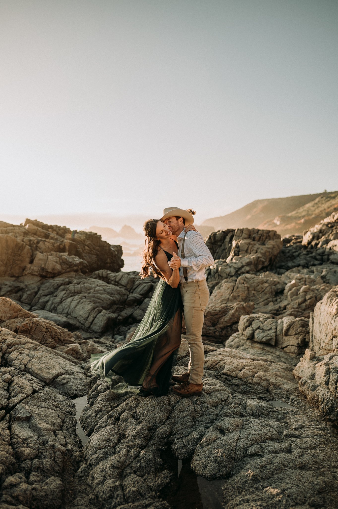 Newly engaged couple dancing cliffside in Big Sur California