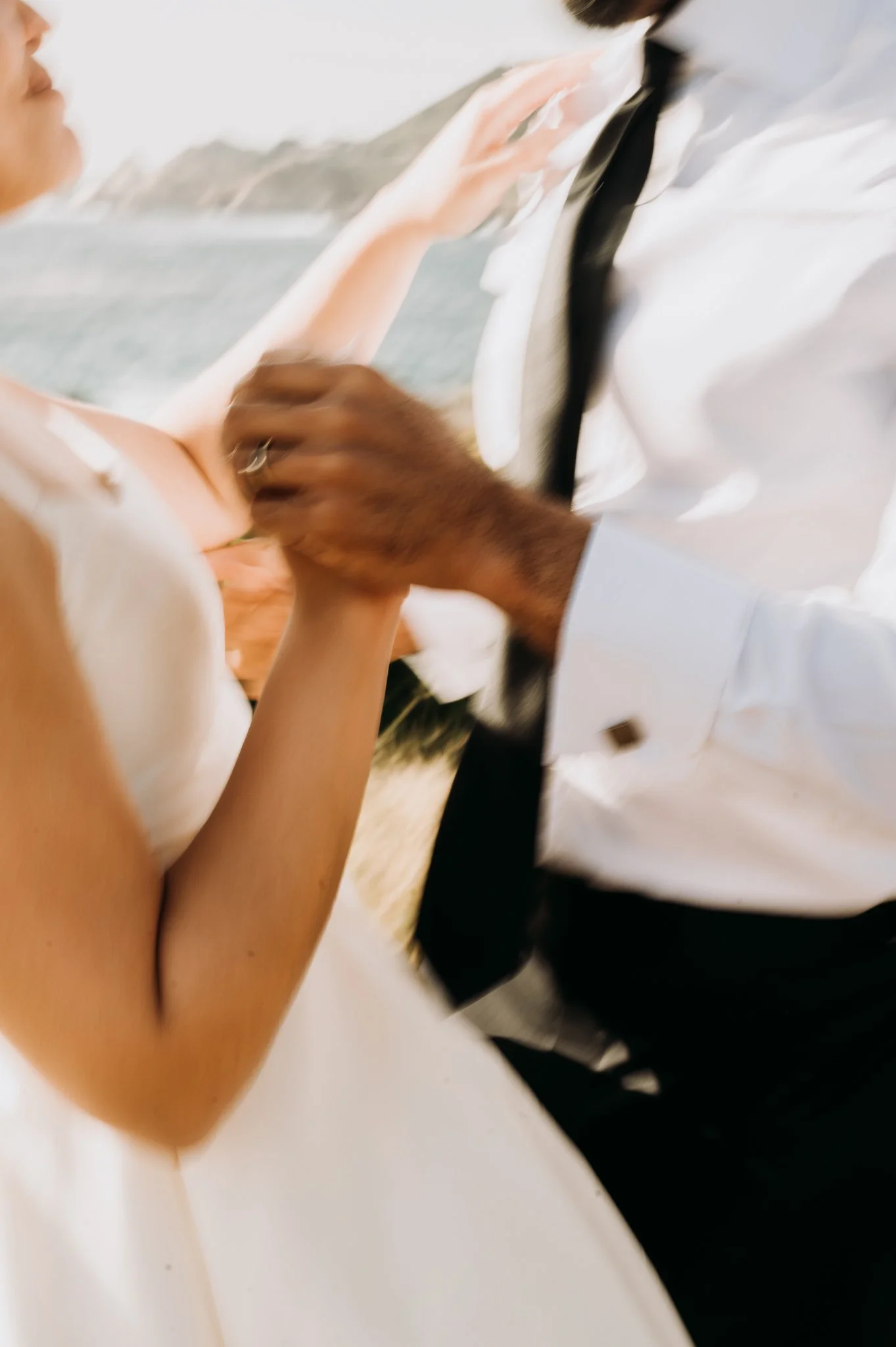 close up of Elopement couple dancing on grassy area above Pacific Ocean Big Sur