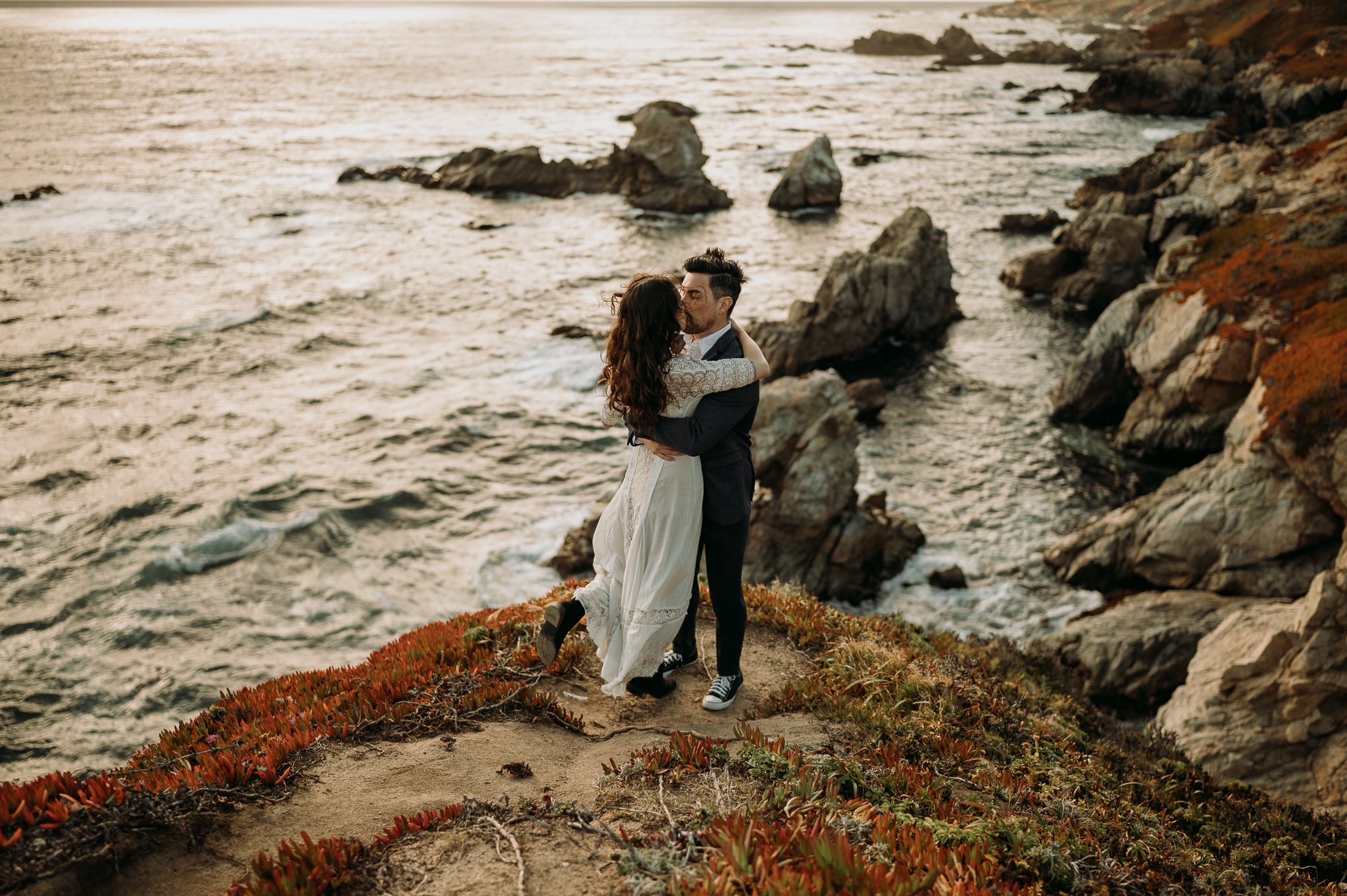 couple embracing on cliffside in Big Sur