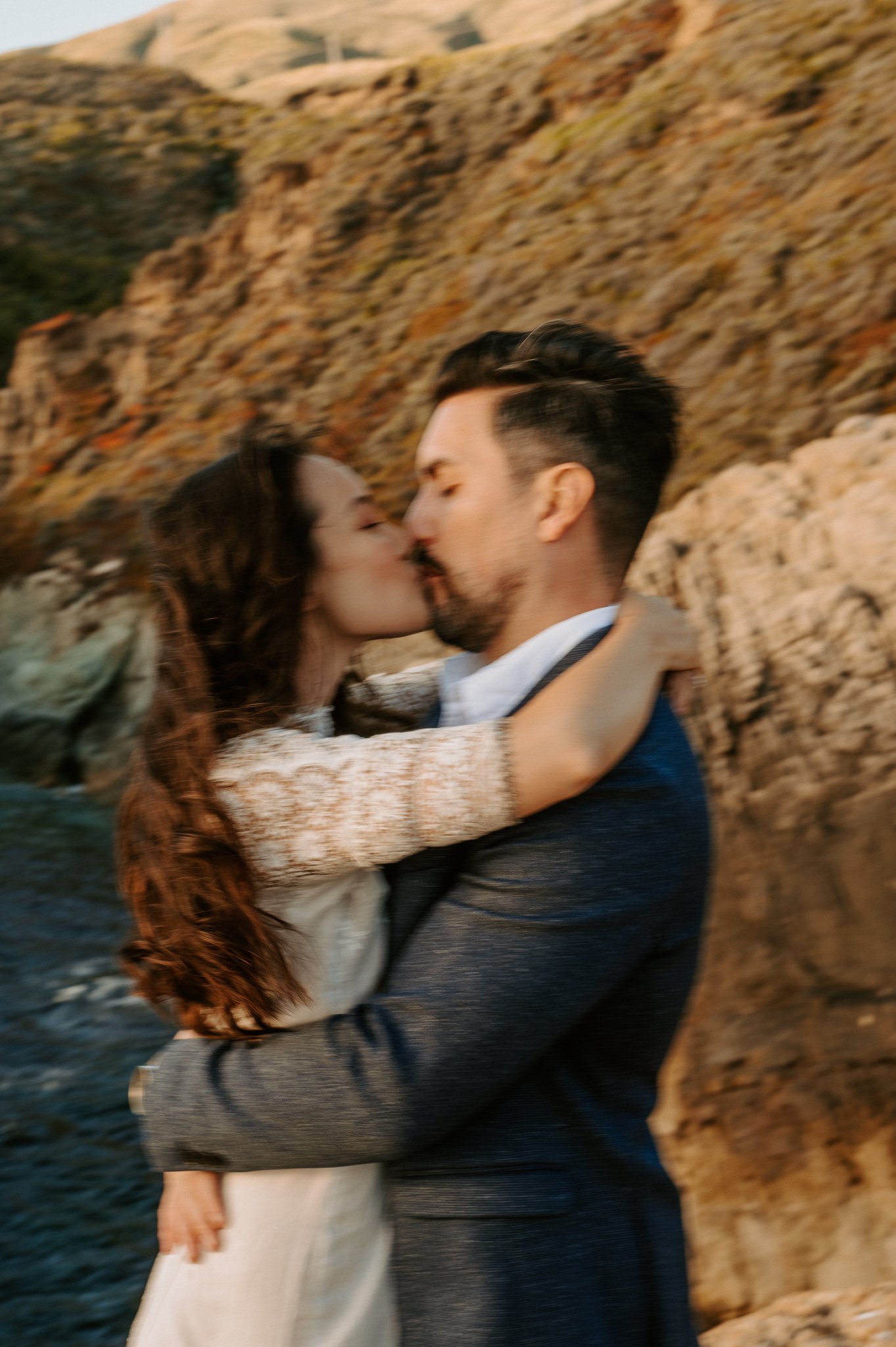 Newly engaged couple kissing on hillside Big Sur, California 