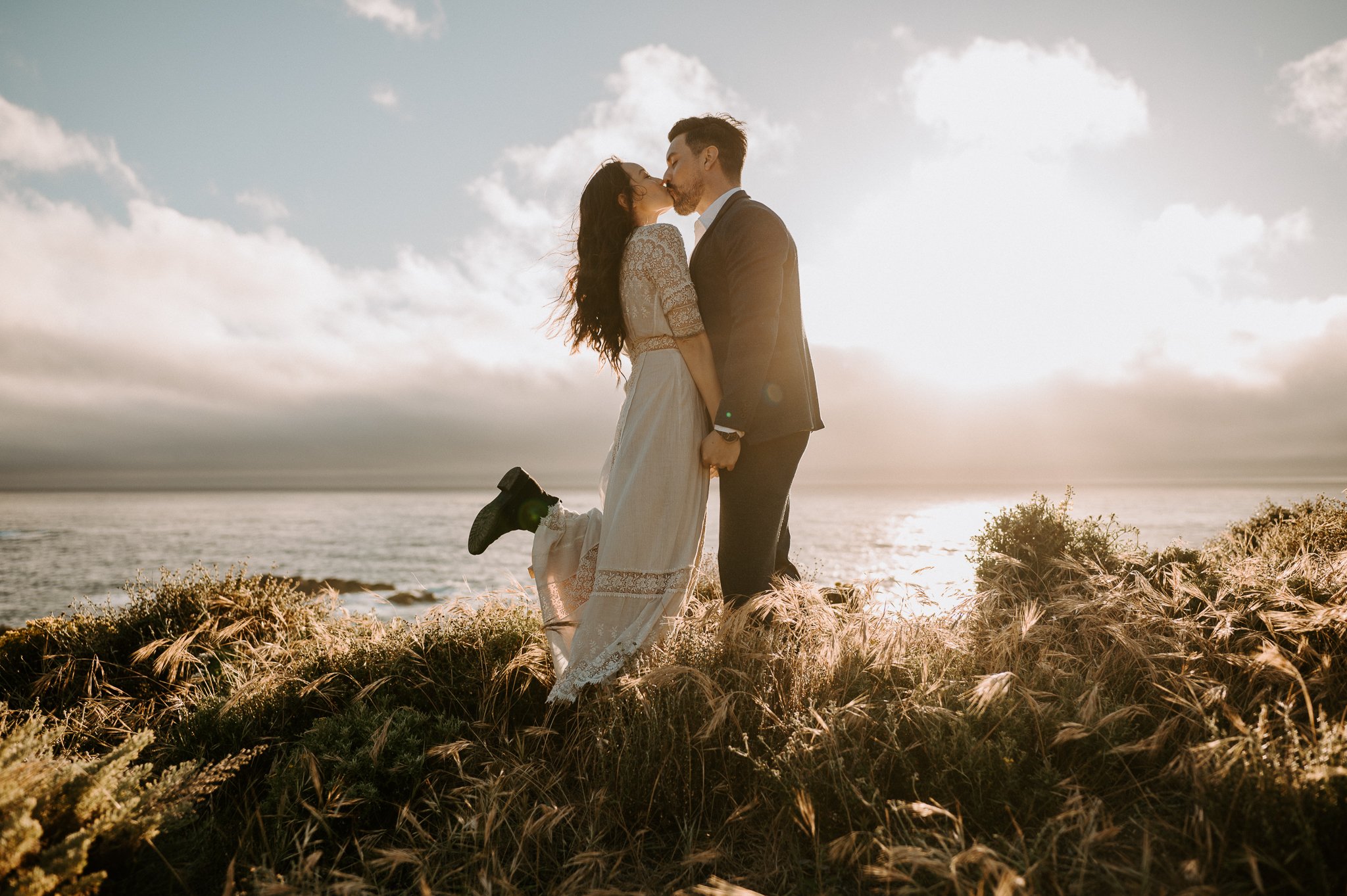 Newly engaged couple kissing on the cliffs of Big Sur, California 
