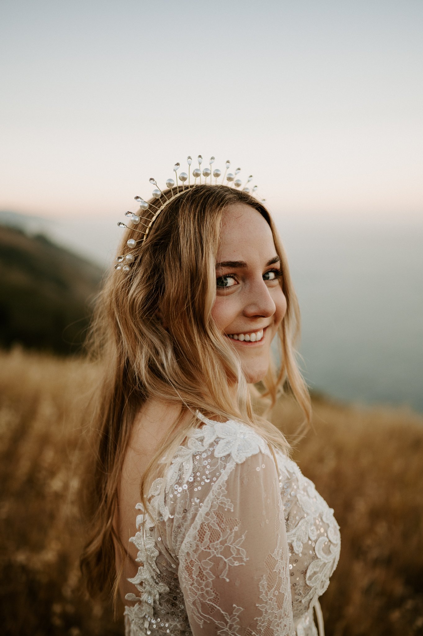 upper brides body with Pacific Ocean in background, bride has a pearl crown on her head