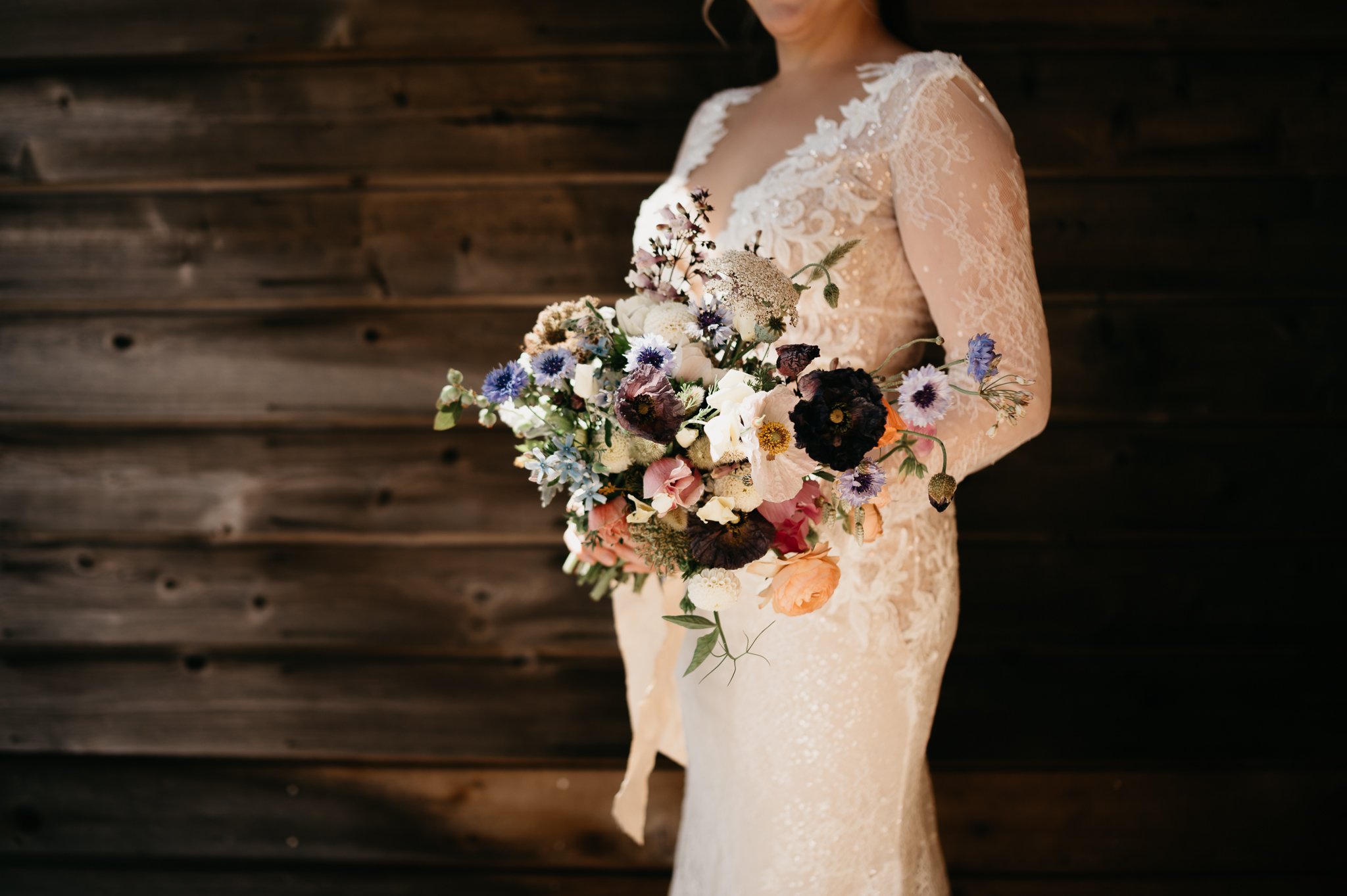 middle body shot of bride in lace wedding dress with bridal bouquet 
