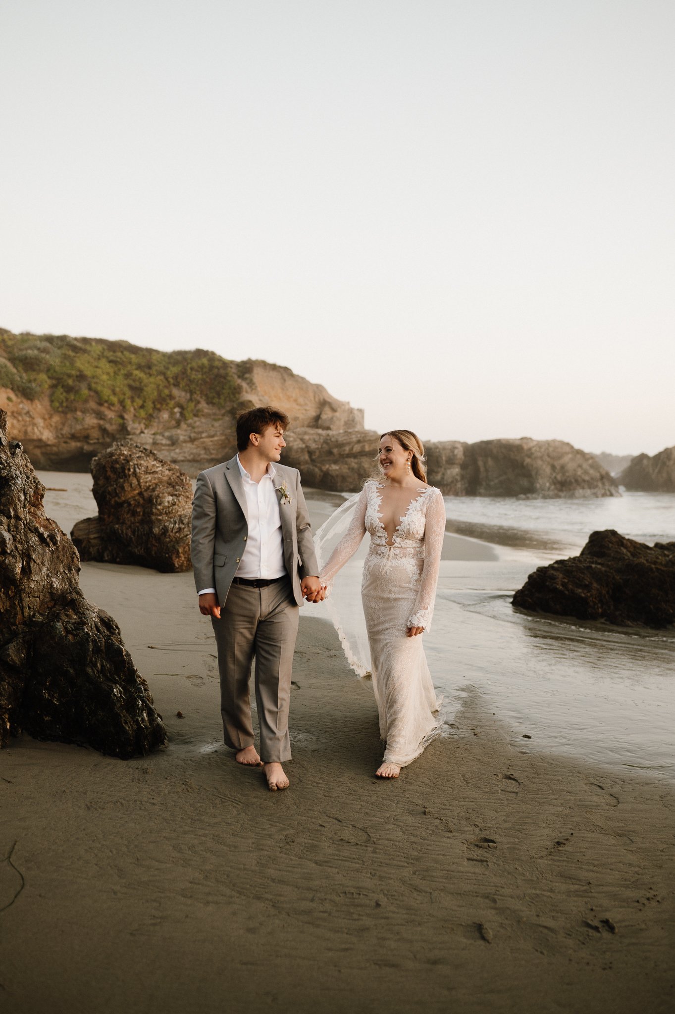 Big Sur bride and groom on walking through water on beach
